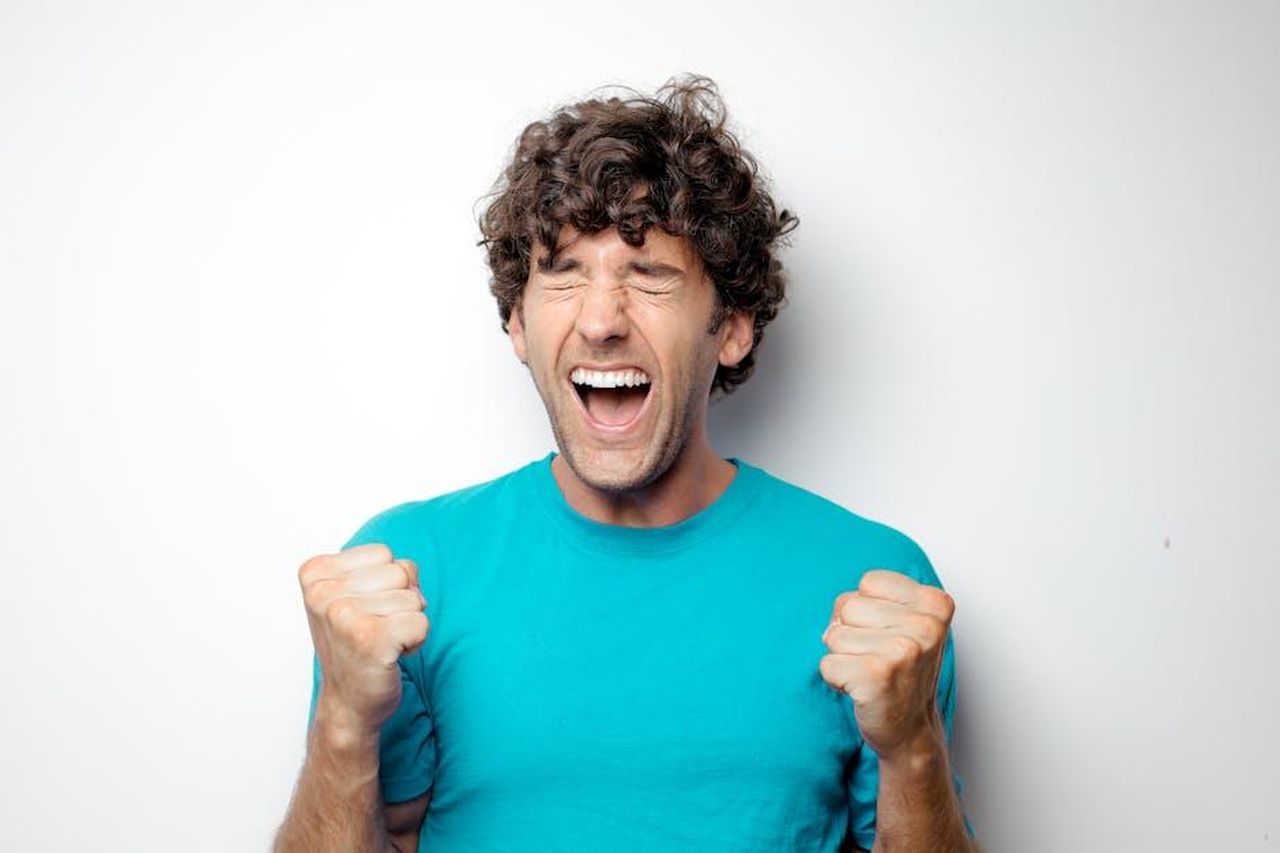 La_reazione_di_Jennifer_Aniston_al_matrimonio_di_Theroux_eUu4JxYUu9 - Confidenze24 Source: Andrea Piacquadio - pexels - Portrait of a joyful man in a blue shirt celebrating with excitement and closed eyes.
