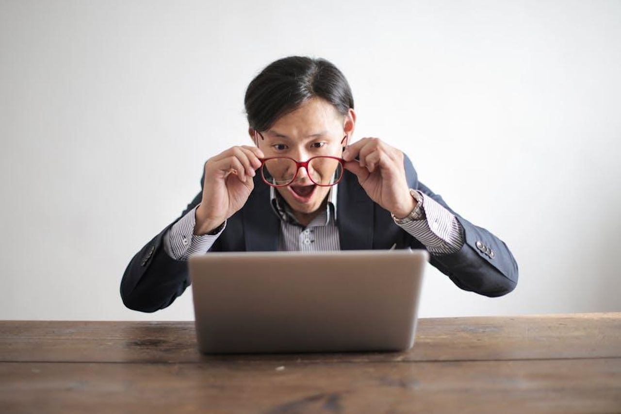 La_reazione_di_Tom_Brady_alla_notizia_della_gravidanza_ycsqs6GPy7 - Confidenze24 Source: Andrea Piacquadio - pexels - Surprised man in a suit looking at laptop, expressing disbelief indoors.