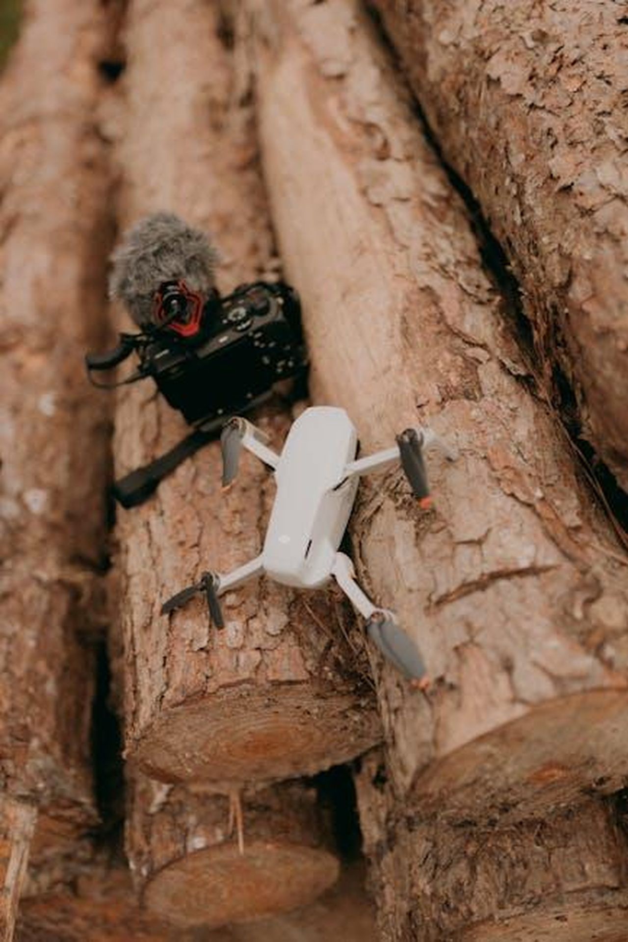 La_registrazione_audio_di_Majors_STfiWASLfZ - Confidenze24 Source: Alexander Mass - pexels - Aerial drone and camera with microphone resting on logs outdoors.