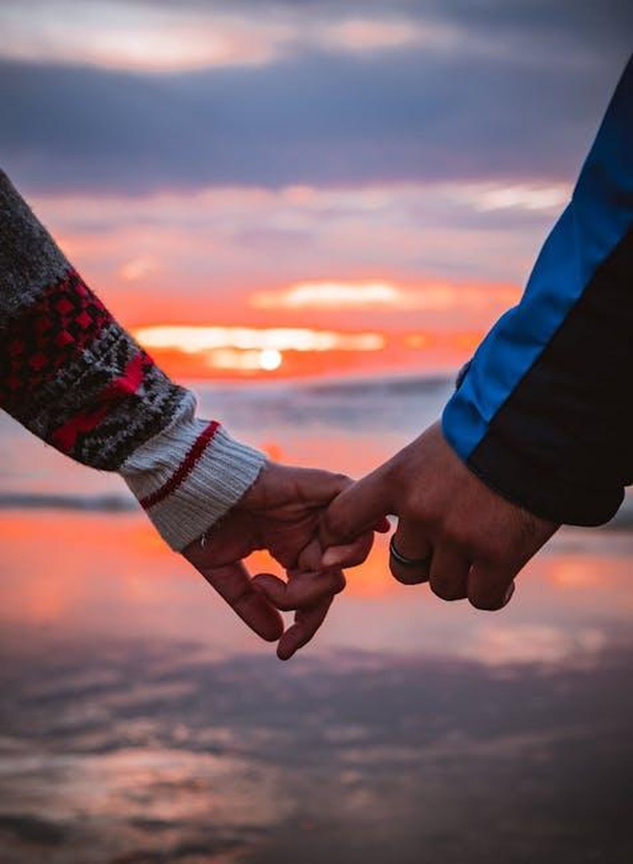 La_relazione_con_Benjamin_Millepied_LXcc7TwS82 - Confidenze24 Source: Achraf Alan - pexels - Close-up of a couple holding hands by the beach during a warm sunset.