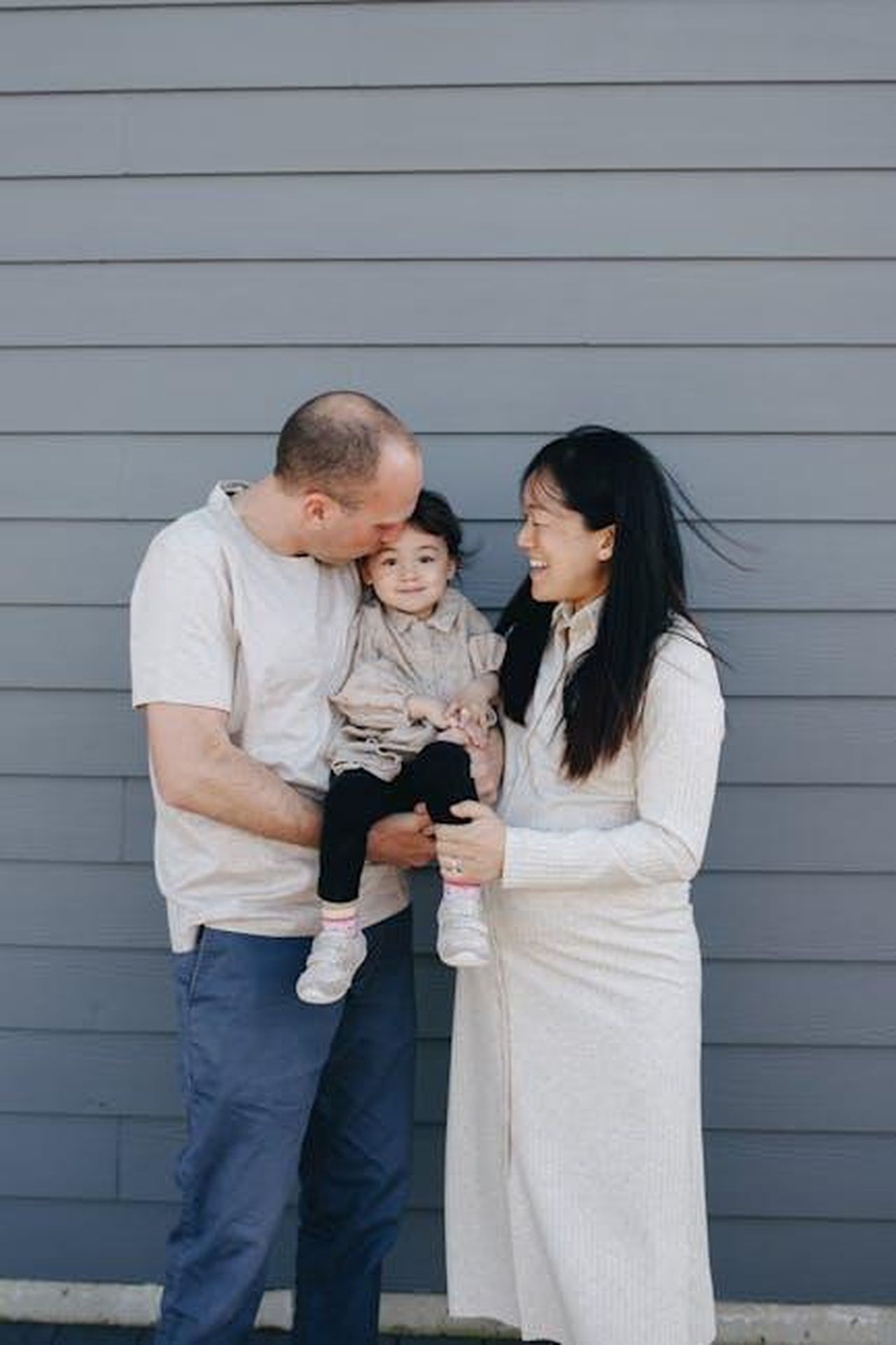 La_relazione_di_Gene_Hackman_con_i_suoi_figli_wUEkFlaPzZ - Confidenze24 Source: PNW Production - pexels - Happy family of three sharing a moment together outdoors against a gray wall.