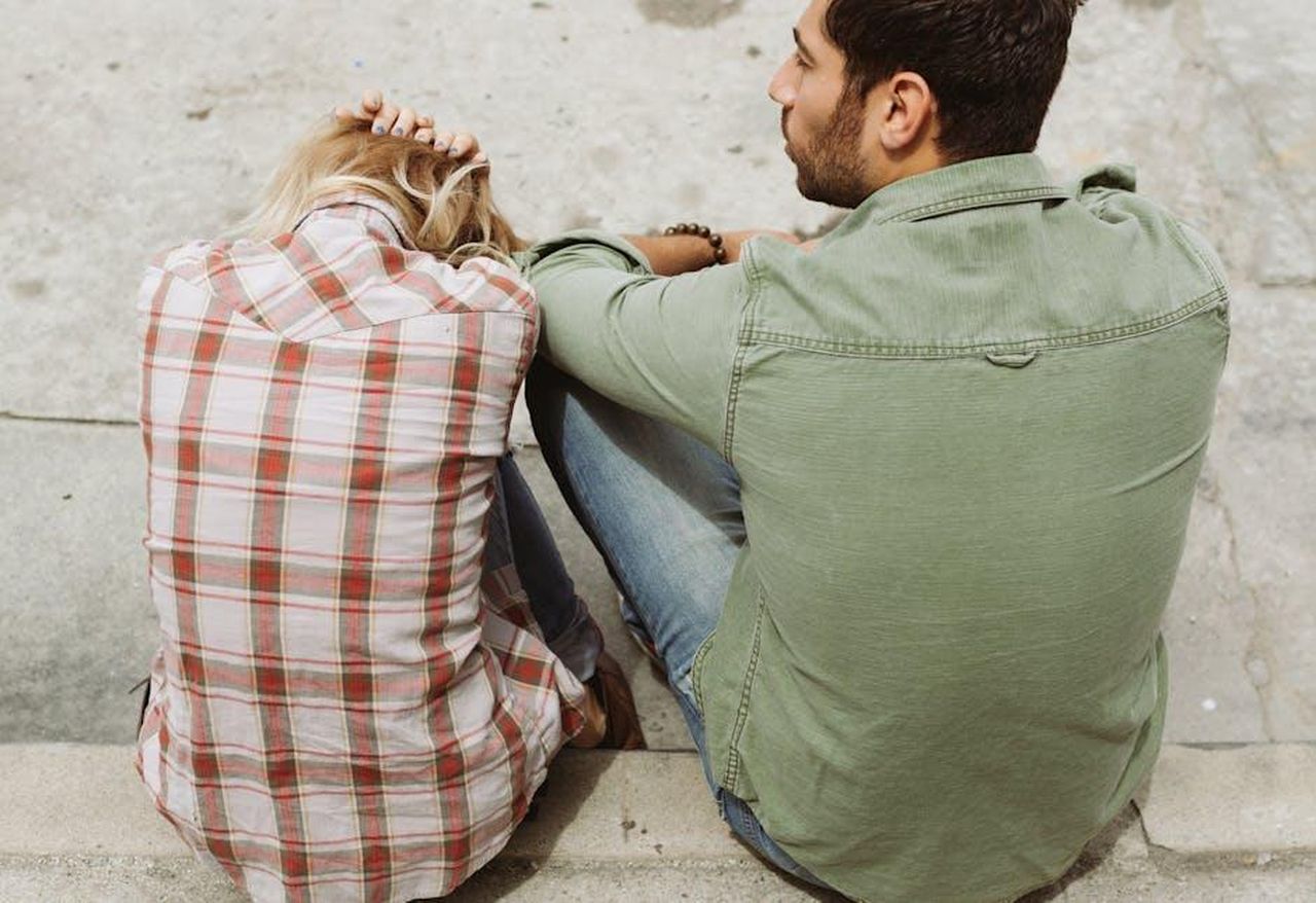 La_relazione_tra_Mark_e_Claire_AZVA9HaJWx - Confidenze24 Source: Odonata Wellnesscenter - pexels - A couple sitting on the street, engaged in a distressed conversation, capturing a moment of emotional tension.