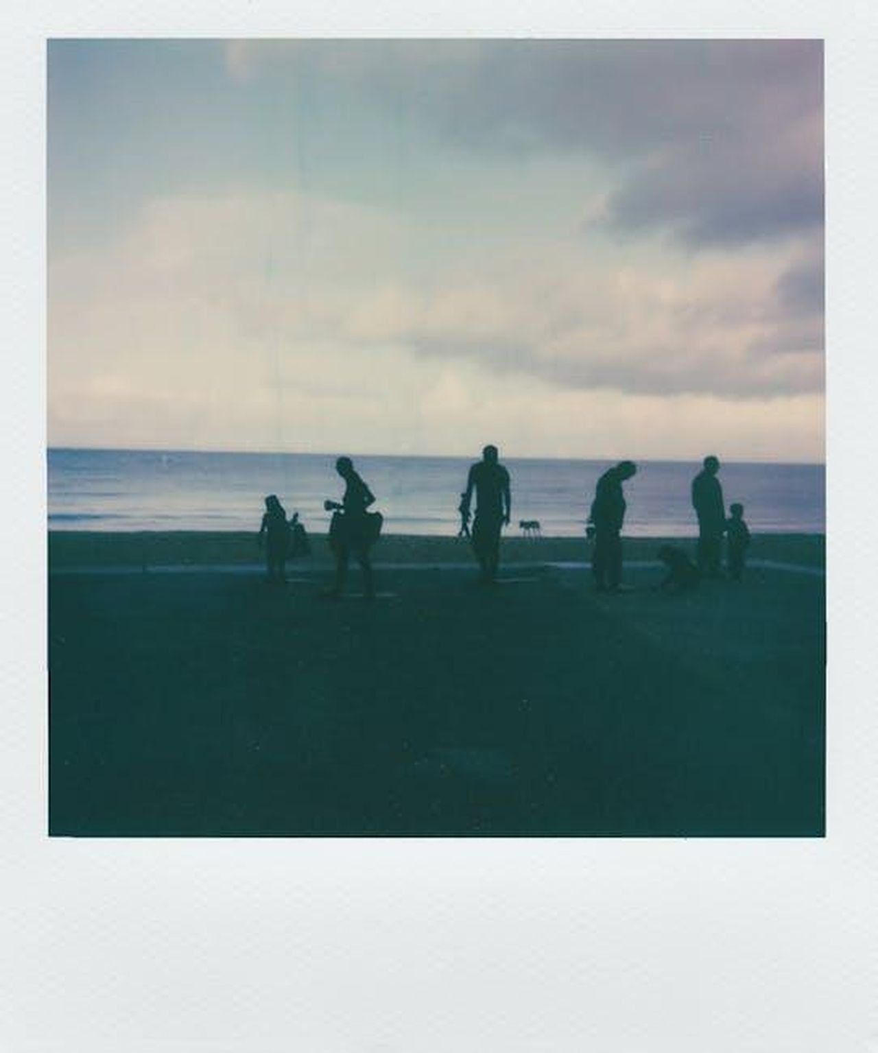 La_ricreazione_di_una_foto_di_famiglia_kc5wgIE4Cs - Confidenze24 Source: Lisa from Pexels - pexels - Silhouettes of people enjoying a serene evening at the beach, captured in vintage instant film style.