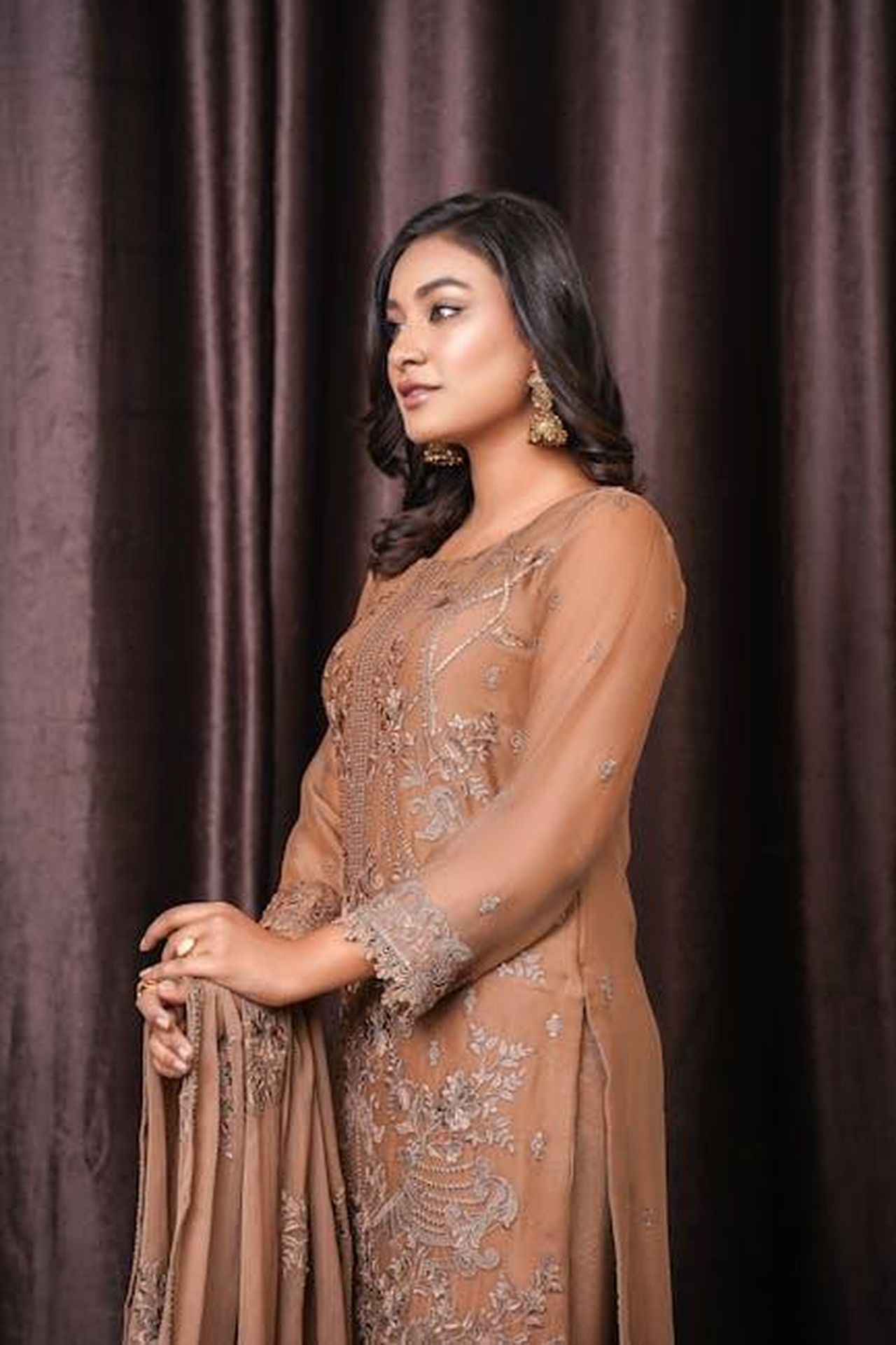 La_sfida_del_trasferimento_a_Londra_jUJC4B4kBg - Confidenze24 Source: Muneeb Malhotra - pexels - Stylish woman in an embroidered brown dress posing in a studio setting.