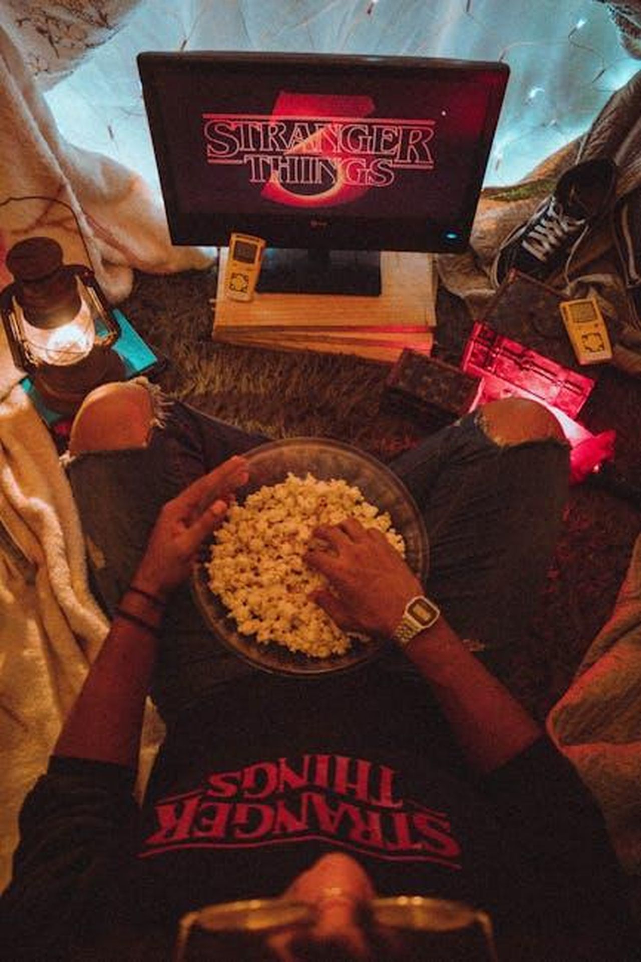 La_stagione_8_di_The_Neighborhood_ha_gi_una_data_di_premiere_BPGHAVsDDu - Confidenze24 Source: David Gomes - pexels - Person enjoying popcorn while watching Stranger Things in a cozy room setup.