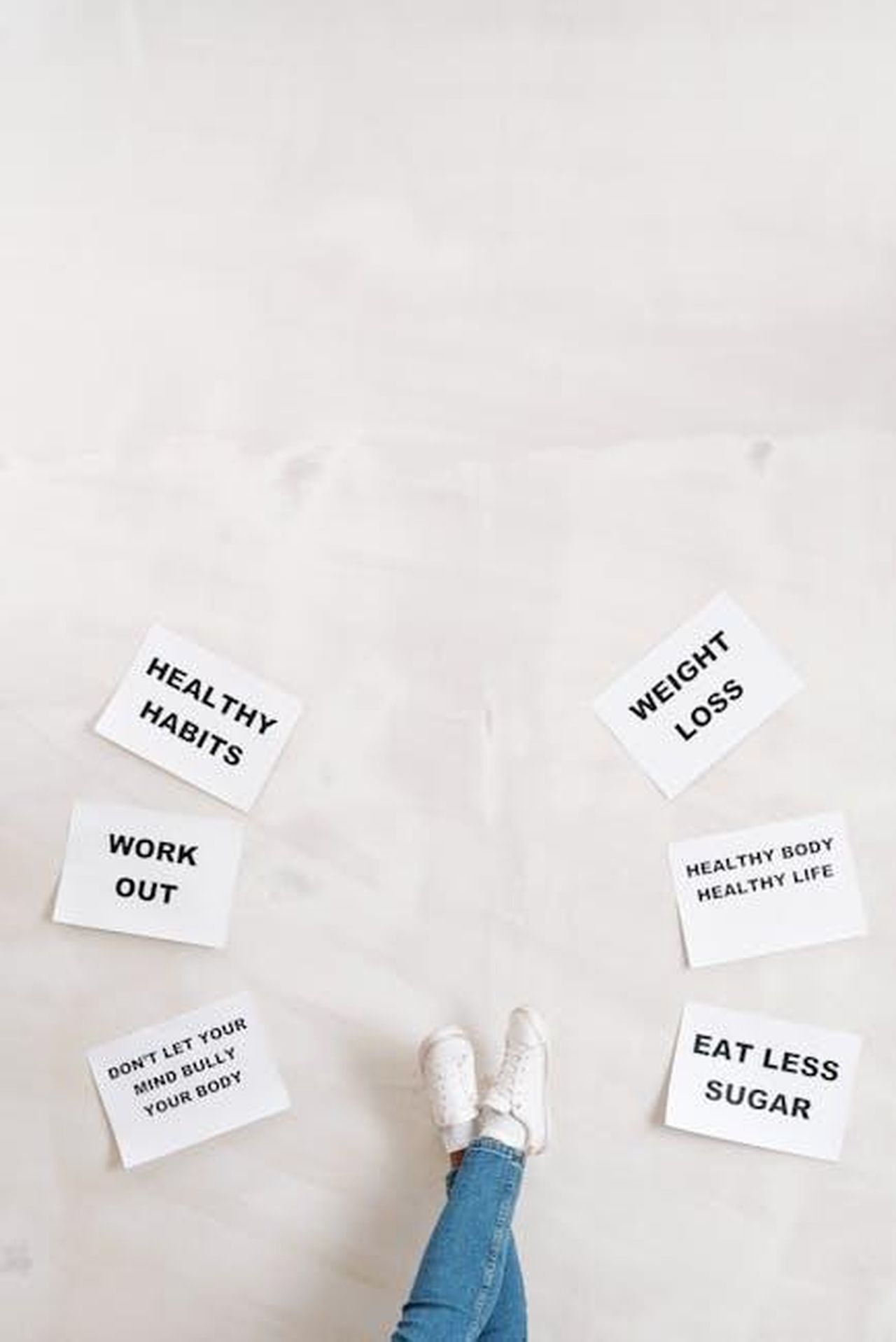 La_star_di_TOWIE_sui_farmaci_per_la_perdita_di_peso_s9sFlzuh7O - Confidenze24 Source: Moe Magners - pexels - Overhead view of motivational boards inspiring healthy lifestyle with casual denim and sneakers.