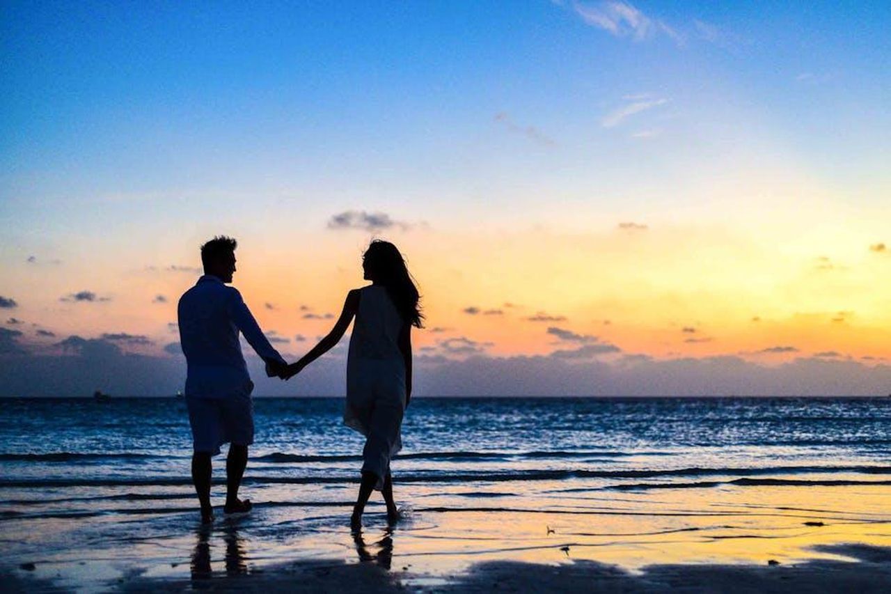 La_storia_damore_di_Chip_e_Joanna_DOGtZI5rM9 - Confidenze24 Source: Asad Photo Maldives - pexels - A romantic couple walks hand in hand on a tropical beach at sunset, enjoying a serene moment together.