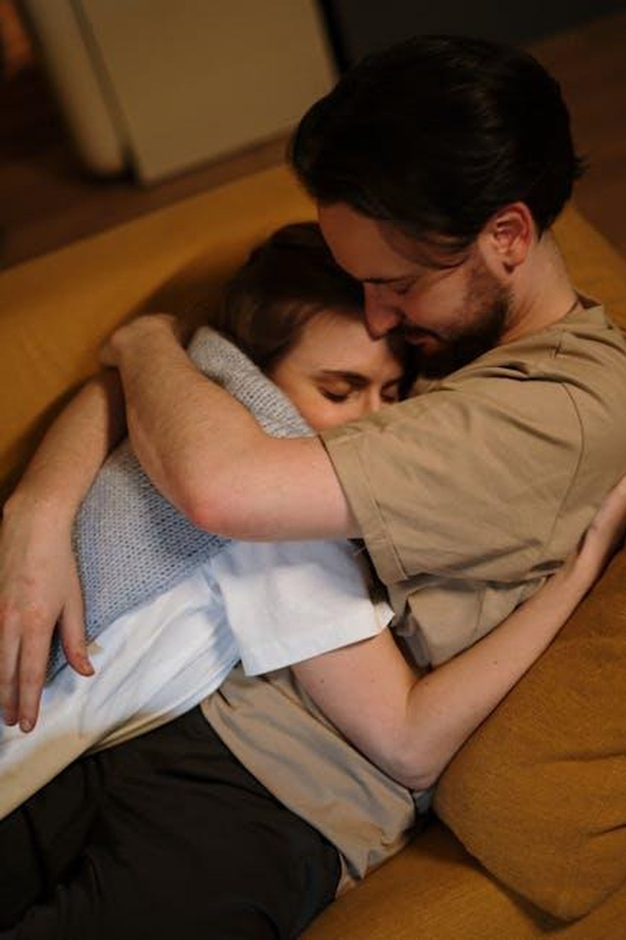 La_storia_damore_di_Dolly_e_Carl_DUxqrqWc5B - Confidenze24 Source: cottonbro studio - pexels - A loving couple embraces warmly on a sofa in a cozy home setting.