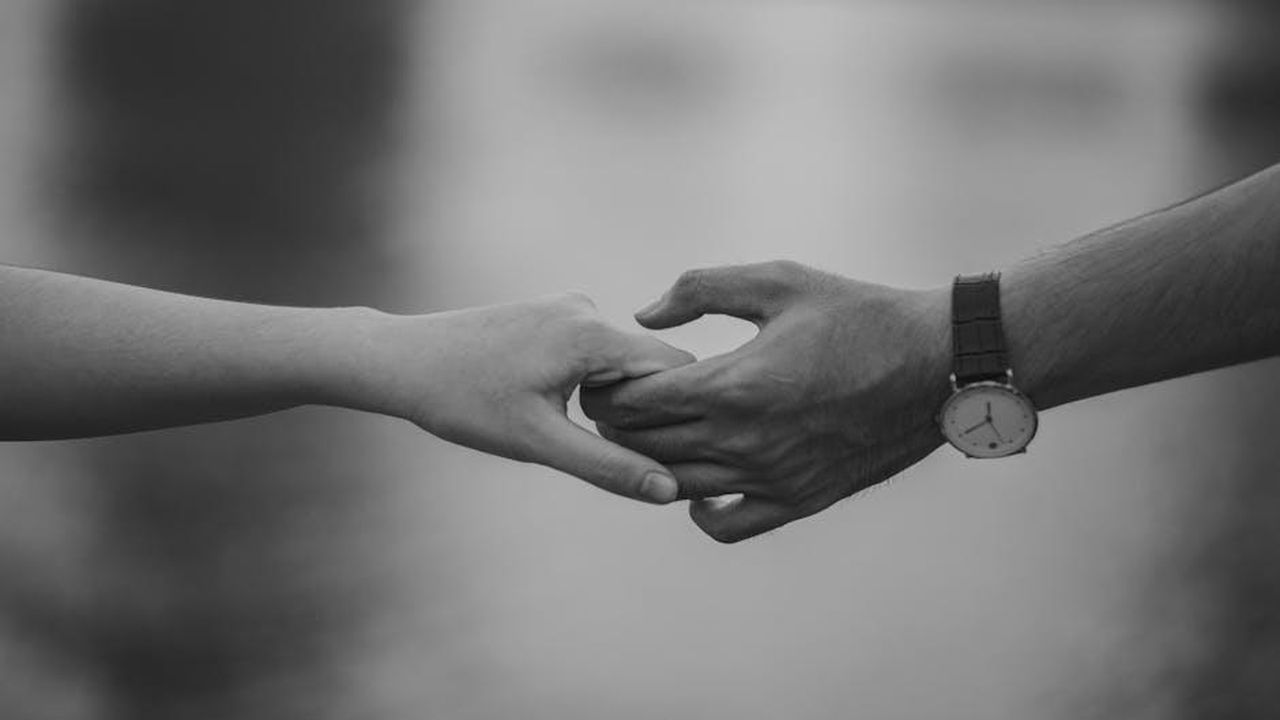 La_storia_damore_di_Justin_e_Nicole_xbPRPRvo2n - Confidenze24 Source: Min An - pexels - Monochrome image of two hands holding, symbolizing love and connection.