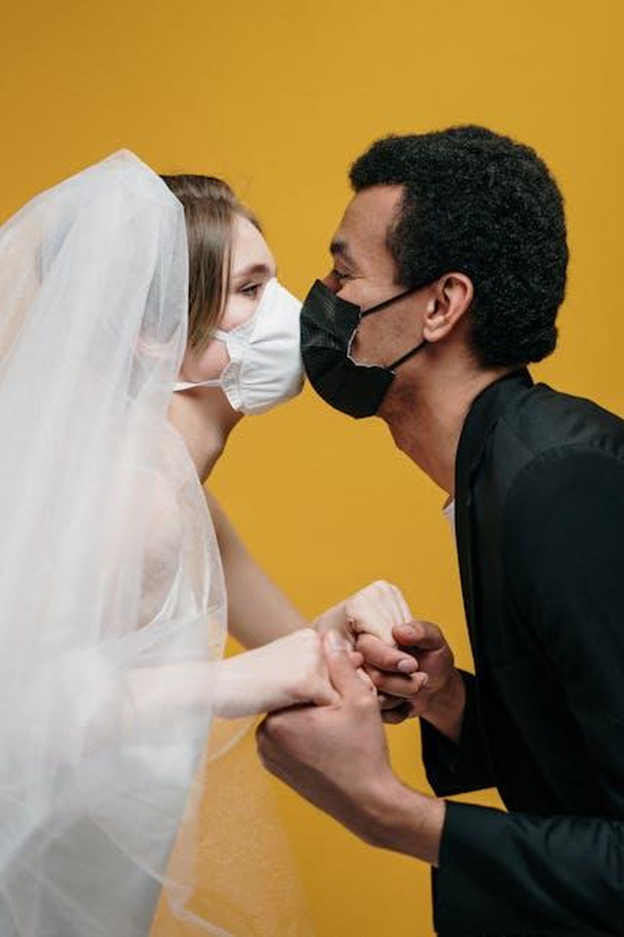 La_storia_damore_di_Lily_Collins_e_Charlie_McDowell_rTNvVIr23Y - Confidenze24 Source: cottonbro studio - pexels - Bride and groom kissing with masks, illustrating pandemic love and protection.