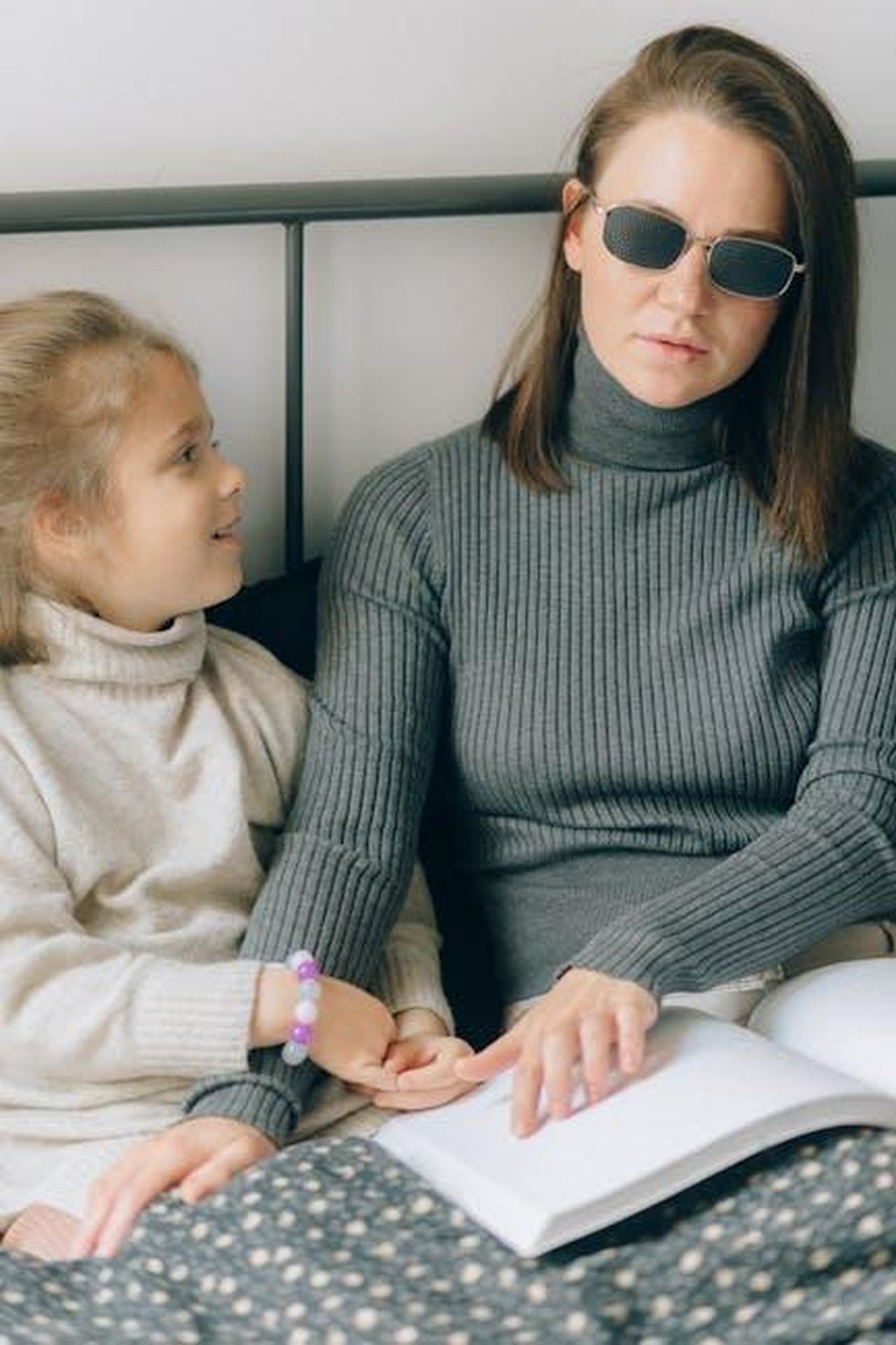 La_storia_damore_di_Monica_e_Joey_xuoGWoLUGB - Confidenze24 Source: Nataliya Vaitkevich - pexels - Woman in sunglasses reading braille with a girl on bed, depicting learning with disability.