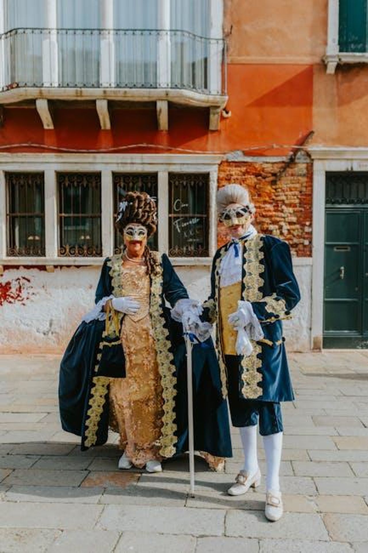 La_storia_damore_di_Naomi_Watts_e_Liev_Schreiber_LKmzkUVR5D - Confidenze24 Source: Helena Jankovičová Kováčová - pexels - Costumed couple in traditional Venetian attire with masks, posing outdoors in Venice.
