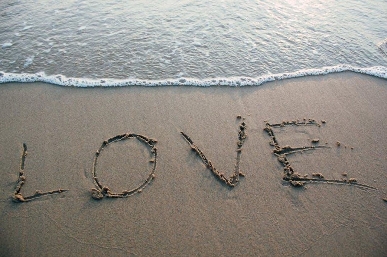 La_storia_damore_di_Robert_e_Jill_269TcfWzqH - Confidenze24 Source: Porapak Apichodilok - pexels - Love written in sand with ocean waves at the beach, evoking romance and tranquility.