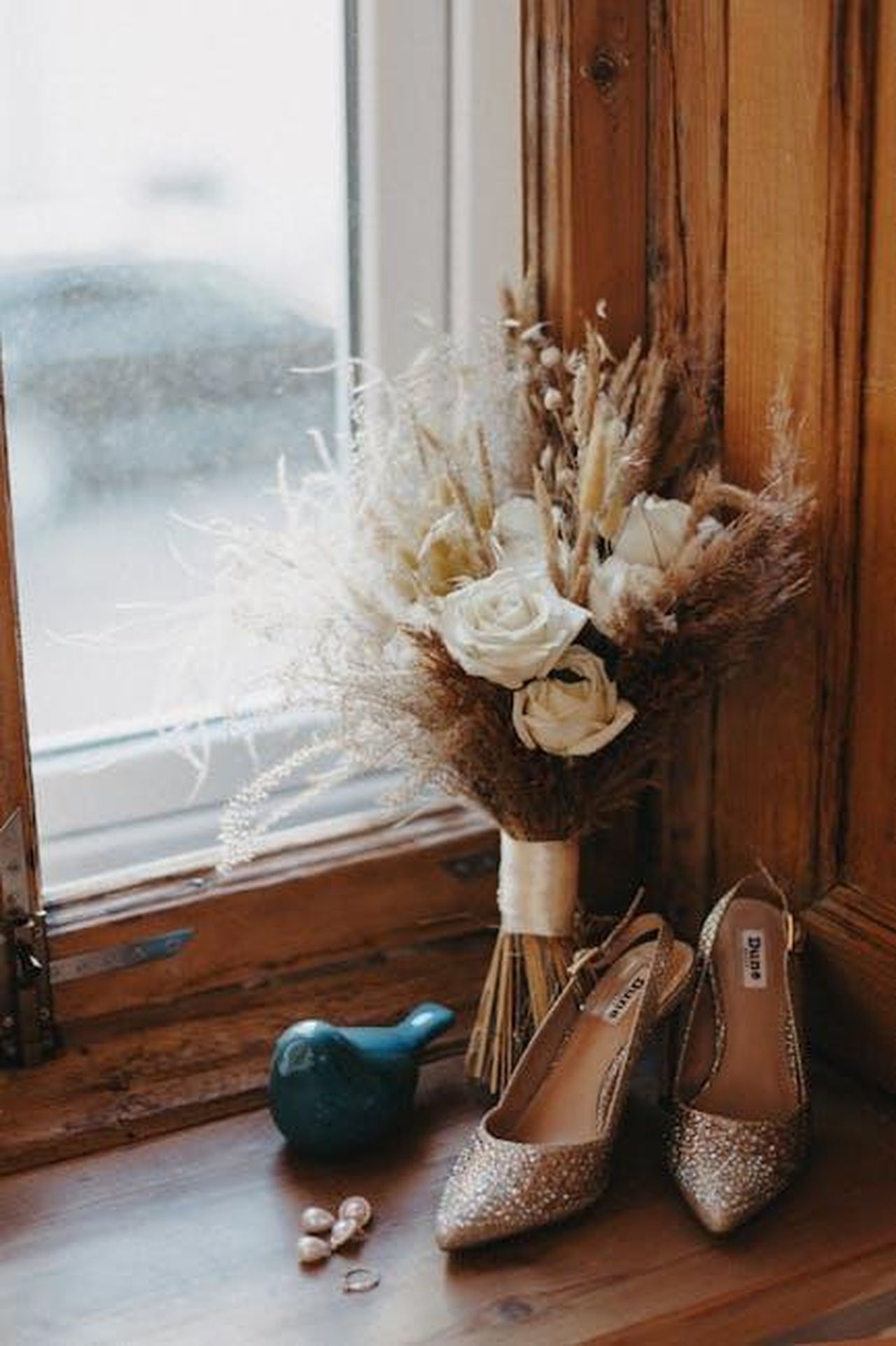 La_storia_damore_di_Shayk_e_Brady_VbZfBcRJ6H - Confidenze24 Source: Anna Khomutova - pexels - A beautiful wedding bouquet with glitter shoes on a rustic windowsill, perfect for bridal themes.