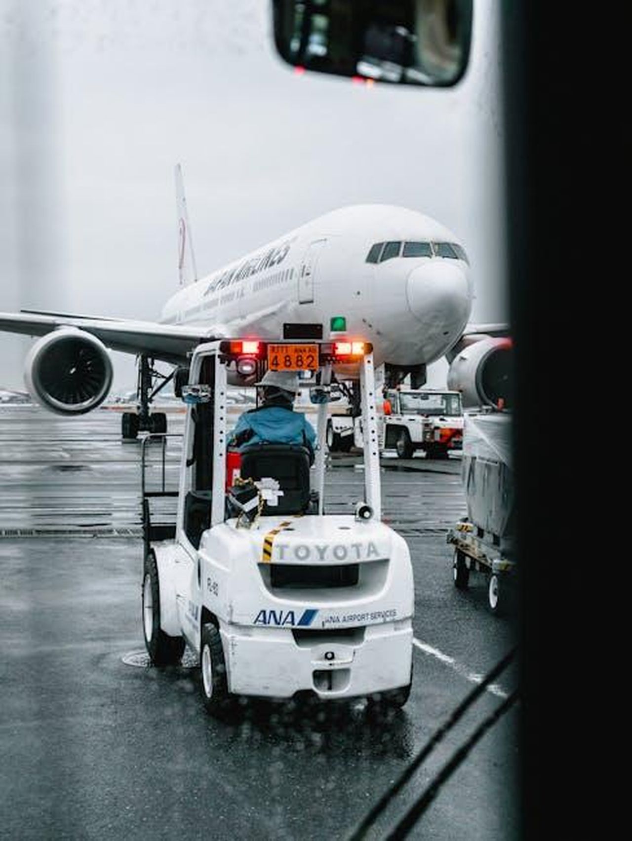La_storia_damore_tra_Ana_de_Armas_e_Ben_Affleck_WcqQnn94Mg - Confidenze24 Source: Matt Hardy - pexels - Airport ground crew operating a vehicle in front of a parked airliner on a rainy runway.