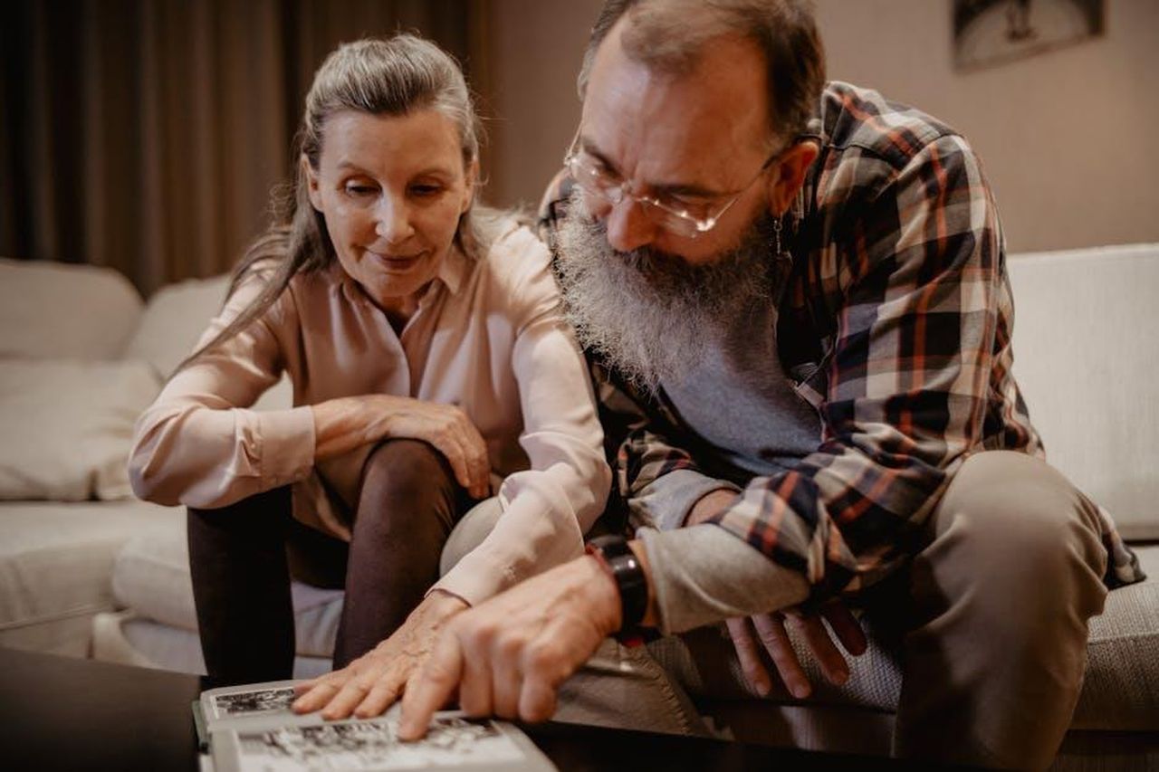 La_storia_di_Jennifer_Garner_e_John_Miller_WVWnQxvg1a - Confidenze24 Source: Mikhail Nilov - pexels - An elderly couple enjoys looking at an album, reminiscing about happy past moments.