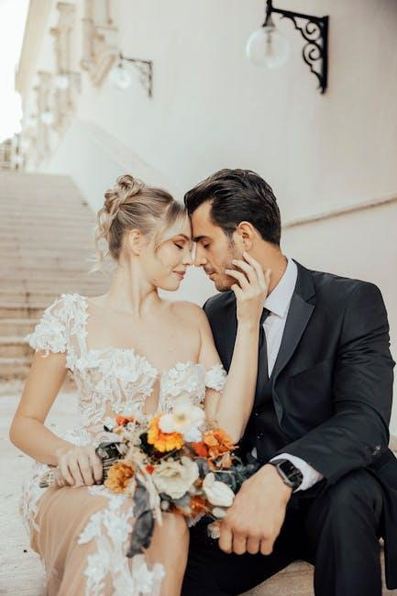 La_storia_di_Katharine_McPhee_e_David_Foster_VwnSuuUPq3 - Confidenze24 Source: OĞUZHAN YAVUZ - pexels - Elegant bride and groom sharing a tender moment on historic stone steps.