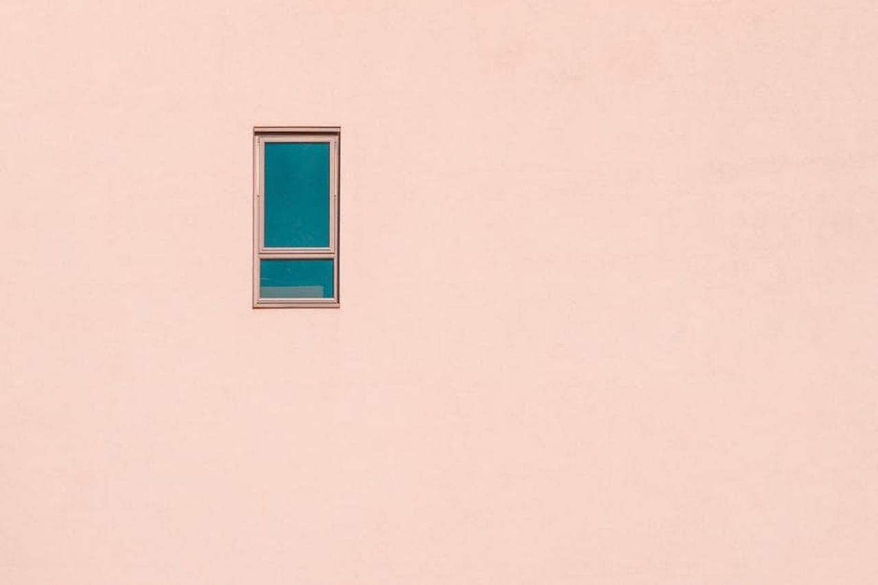 La_sua_visione_estetica_e_il_concetto_di_eccentrico_xod91kF0ej - Confidenze24 Source: Vlado Paunovic - pexels - A minimalist pastel pink wall featuring a single rectangular window, offering ample negative space.