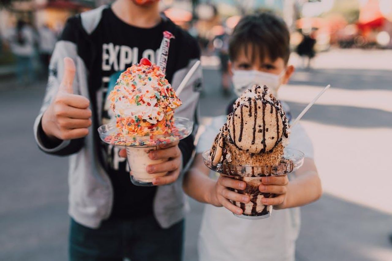 La_verit_sui_waffle_congelati_JkgL8iWN5s - Confidenze24 Source: RDNE Stock project - pexels - Children having fun with large ice cream sundaes at an outdoor event, showing joy and excitement.