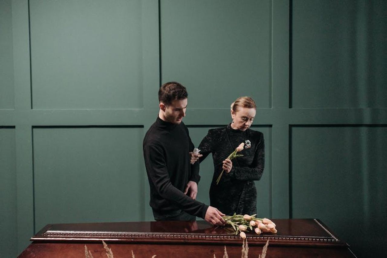 La_vita_di_Finley_dopo_la_morte_della_madre_cyFiTQydmu - Confidenze24 Source: Pavel Danilyuk - pexels - A somber moment of two relatives paying respects at a funeral indoors.