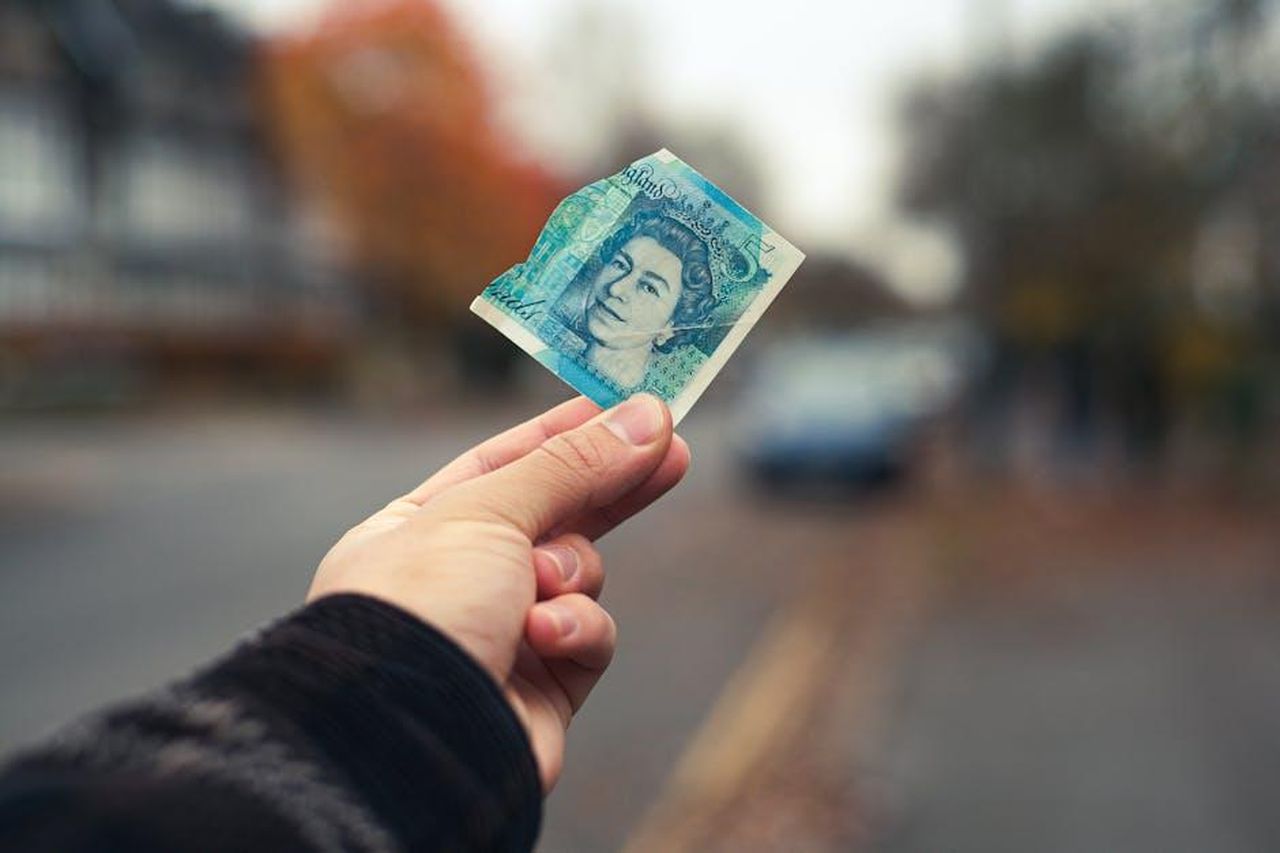 La_vita_familiare_di_Beatrice_e_Edoardo_NqwcJLMso7 - Confidenze24 Source: Leopoldo Fernandez - pexels - A hand holds a torn British pound note on a street in Cambridge, UK.