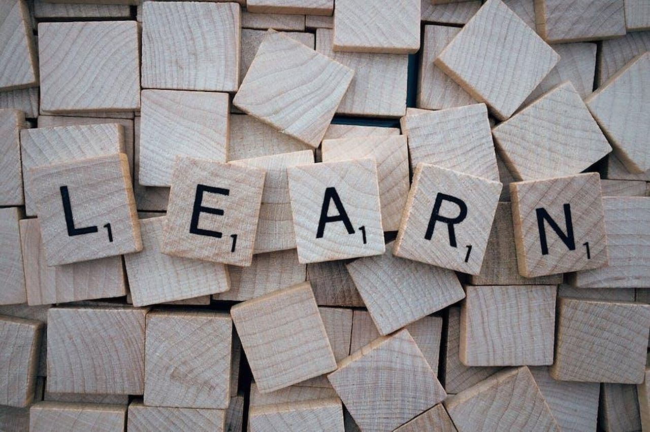 Lapprendimento_del_gallese_su_Duolingo_t8w0HwTgZt - Confidenze24 Source: Pixabay - pexels - Wooden letter tiles arranged to spell 'learn' on a background of scattered tiles.