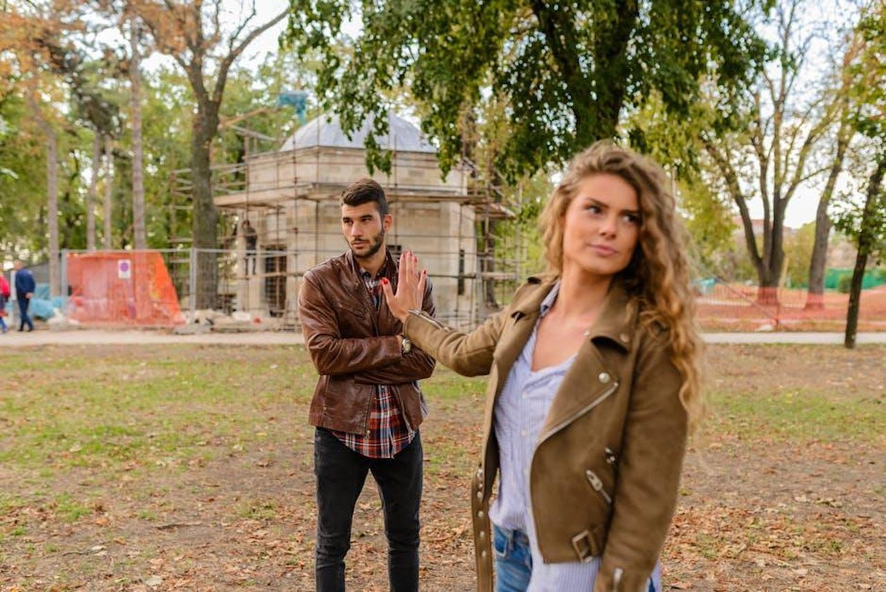 Le_Opinioni_dei_Cofondatori_su_Amore_e_Relazioni_vJnIBLfnL5 - Confidenze24 Source: Vera Arsic - pexels - A couple faces disagreement outdoors in a park setting showcasing emotional expressions.