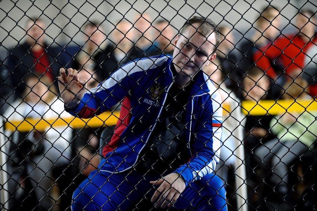 Le_aspettative_dei_fan_per_Boston_Blue_bLdDWnIfU2 - Confidenze24 Source: Dmitrii Eremin - pexels - Athlete in tracksuit focuses through a fence at a match with spectators in background.