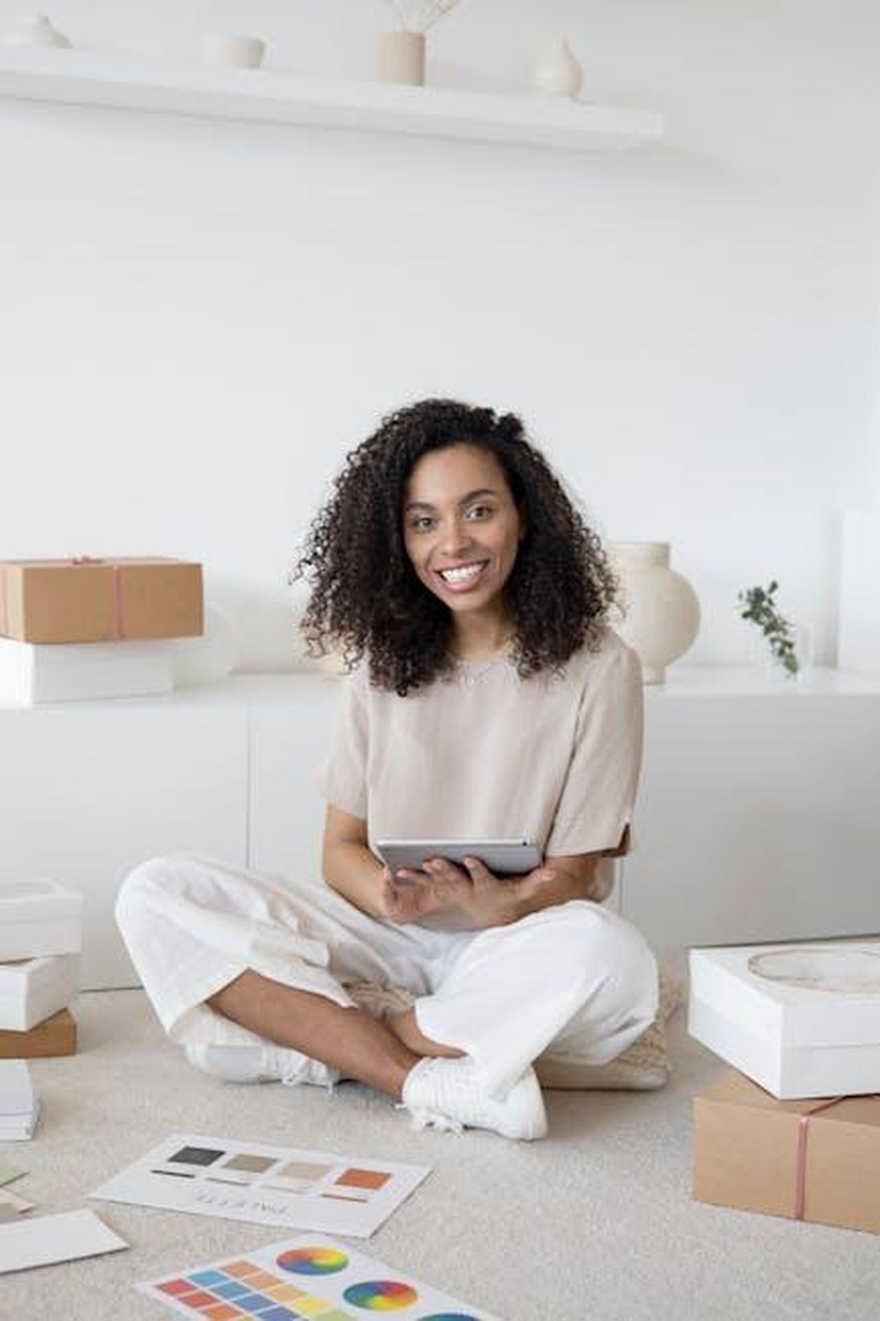 Le_commissioni_di_ShopMy_a07BsjiZ72 - Confidenze24 Source: Anna Nekrashevich - pexels - A confident young woman sitting among packages and papers while using a tablet, showcasing modern entrepreneurship.
