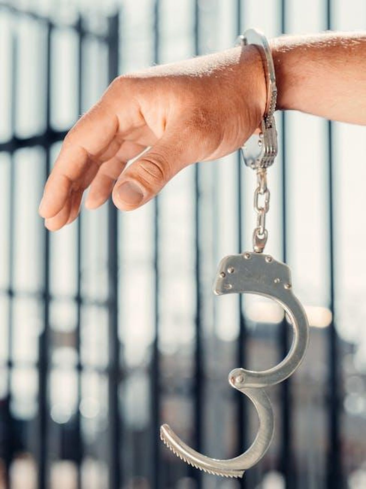 Le_considerazioni_legali_di_Kim_JAvUioLMWL - Confidenze24 Source: Kindel Media - pexels - A close-up, conceptual shot of a handcuffed hand with one open handcuff against blurred bars.