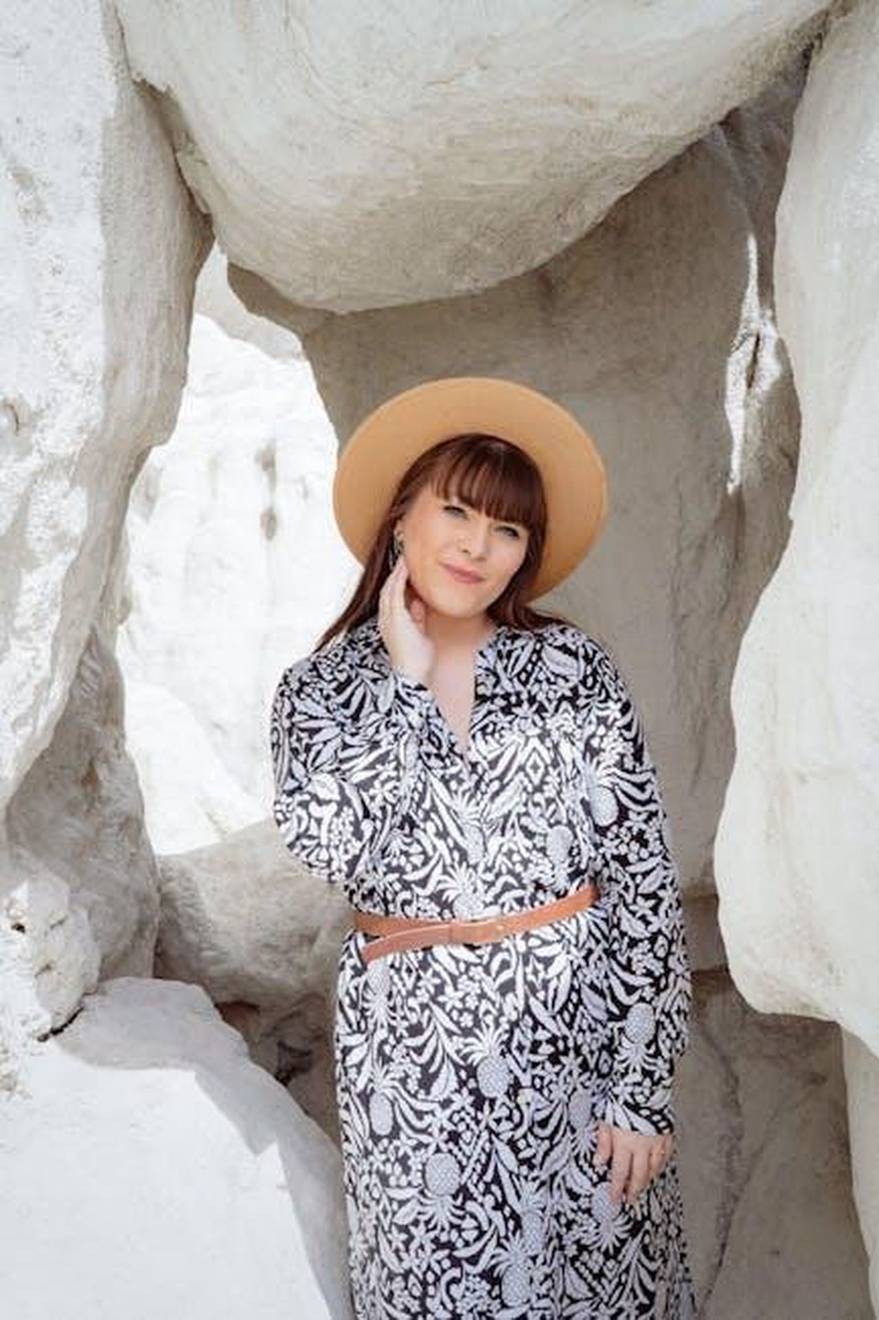 Le_controversie_familiari_e_la_custodia_mhMAnp2cpZ - Confidenze24 Source: Rachel Brooks - pexels - A woman in a black and white dress and straw hat posing amid rocky formations.