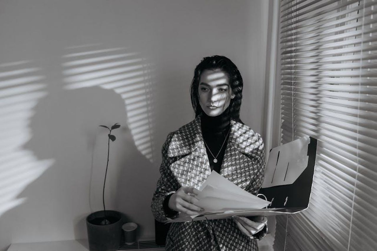 Le_dichiarazioni_dellavvocato_di_Drake_WEXBbRbpC0 - Confidenze24 Source: cottonbro studio - pexels - Business woman in black and white, reviewing documents with blinds creating shadows.