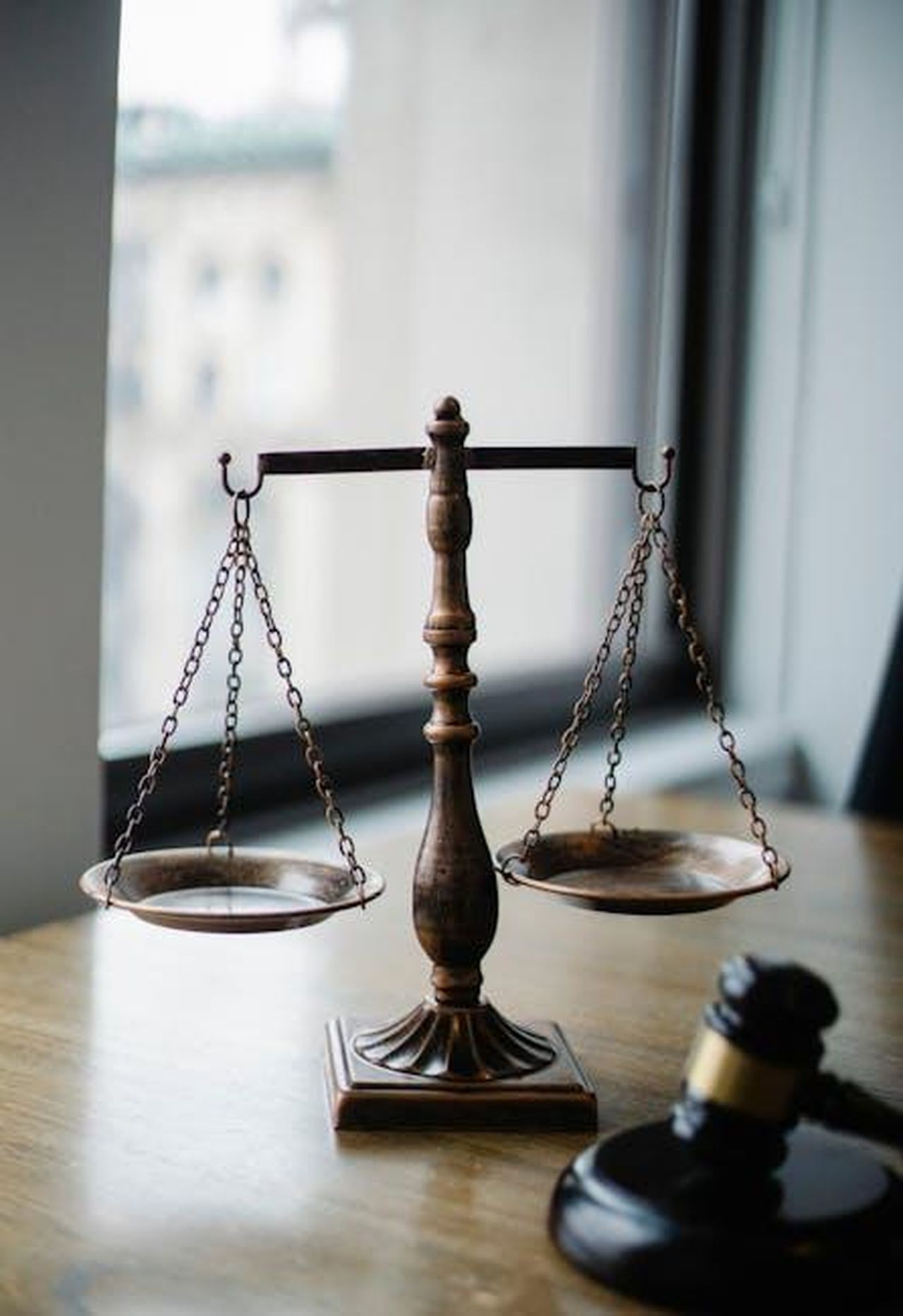 Le_dichiarazioni_di_Druski_xYuWEfsfuY - Confidenze24 Source: Sora Shimazaki - pexels - Decorative judgement scale and gavel placed on desk in light lawyer office against window