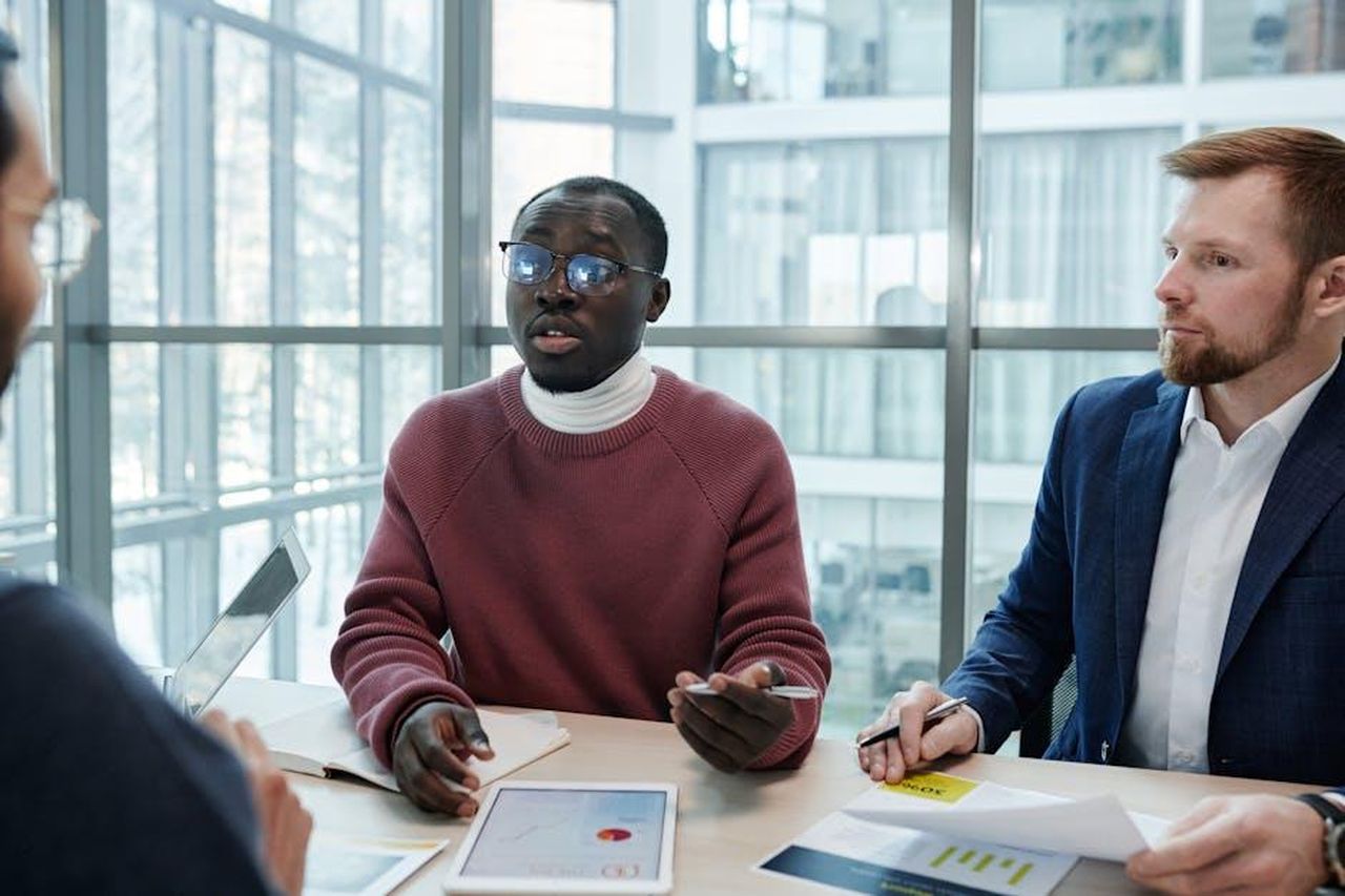 Le_dichiarazioni_di_Peter_Dinklage_e_le_reazioni_politiche_Uttz1CZyvg - Confidenze24 Source: Tiger Lily - pexels - A group of professionals engaged in a business meeting, discussing reports with digital tablets.