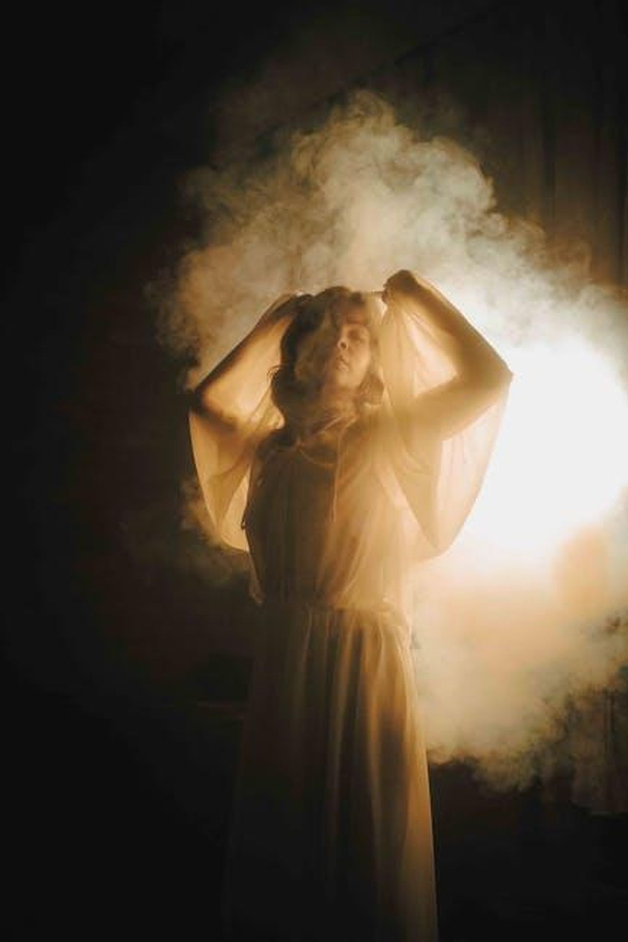 Le_dichiarazioni_di_Toya_BushHarris_yQYBmsdmnd - Confidenze24 Source: Daniil Kondrashin - pexels - A woman enveloped in mist, illuminated by soft, warm lighting, creating an ethereal atmosphere.
