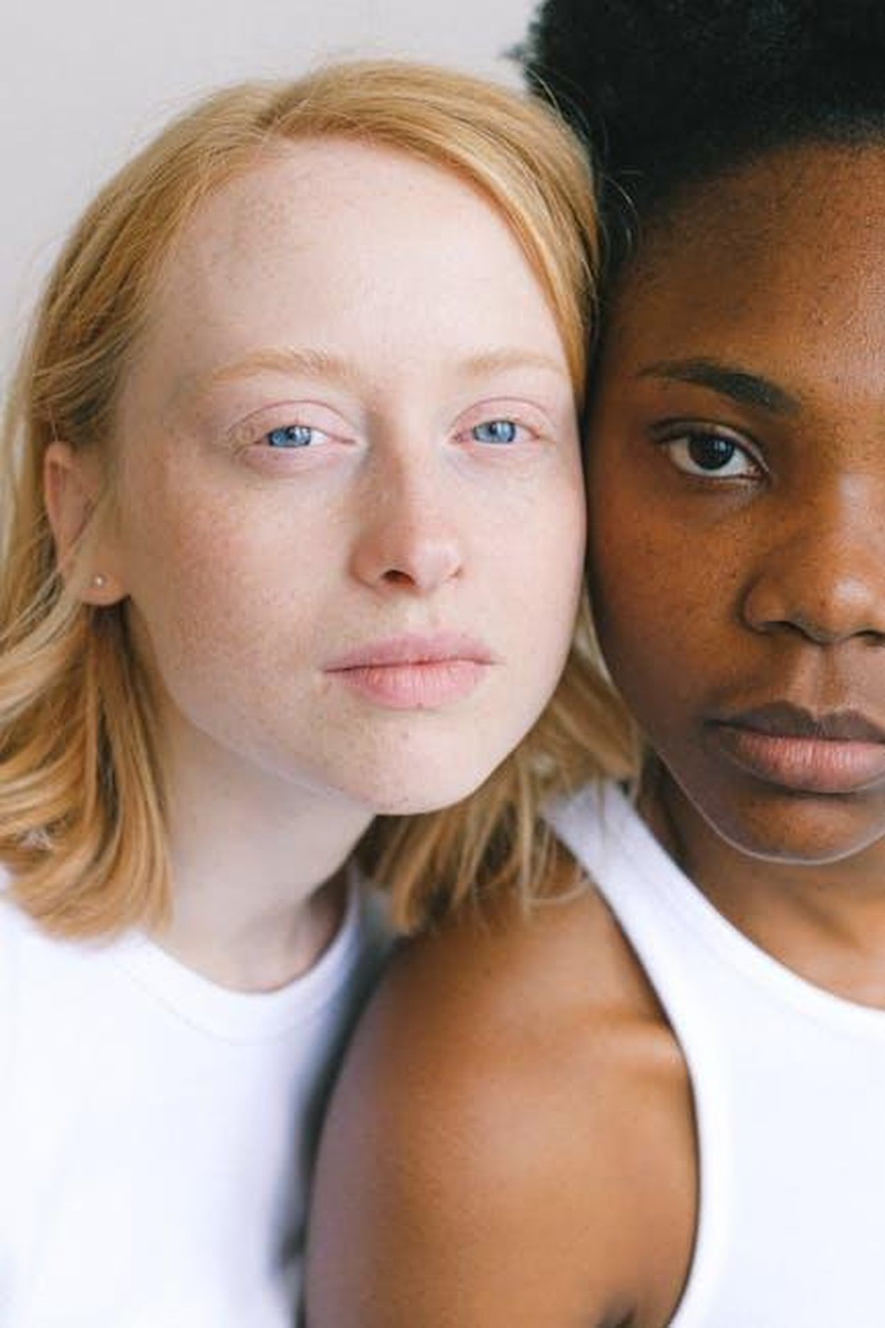 Le_differenze_tra_Devin_e_Virginia_1kAPVGcI0x - Confidenze24 Source: Anna Shvets - pexels - Close-up portrait of interracial friendship showcasing diversity and connection.