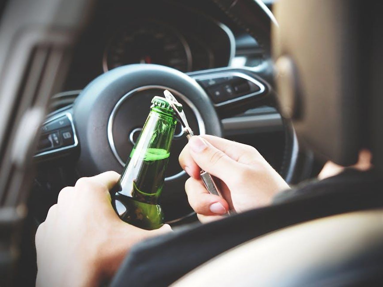 Le_difficolt_legali_di_Grimes_con_Musk_GWCNGHfmYR - Confidenze24 Source: energepic.com - pexels - Hands opening a beer bottle inside a car, highlighting the importance of safe driving and awareness of road dangers.