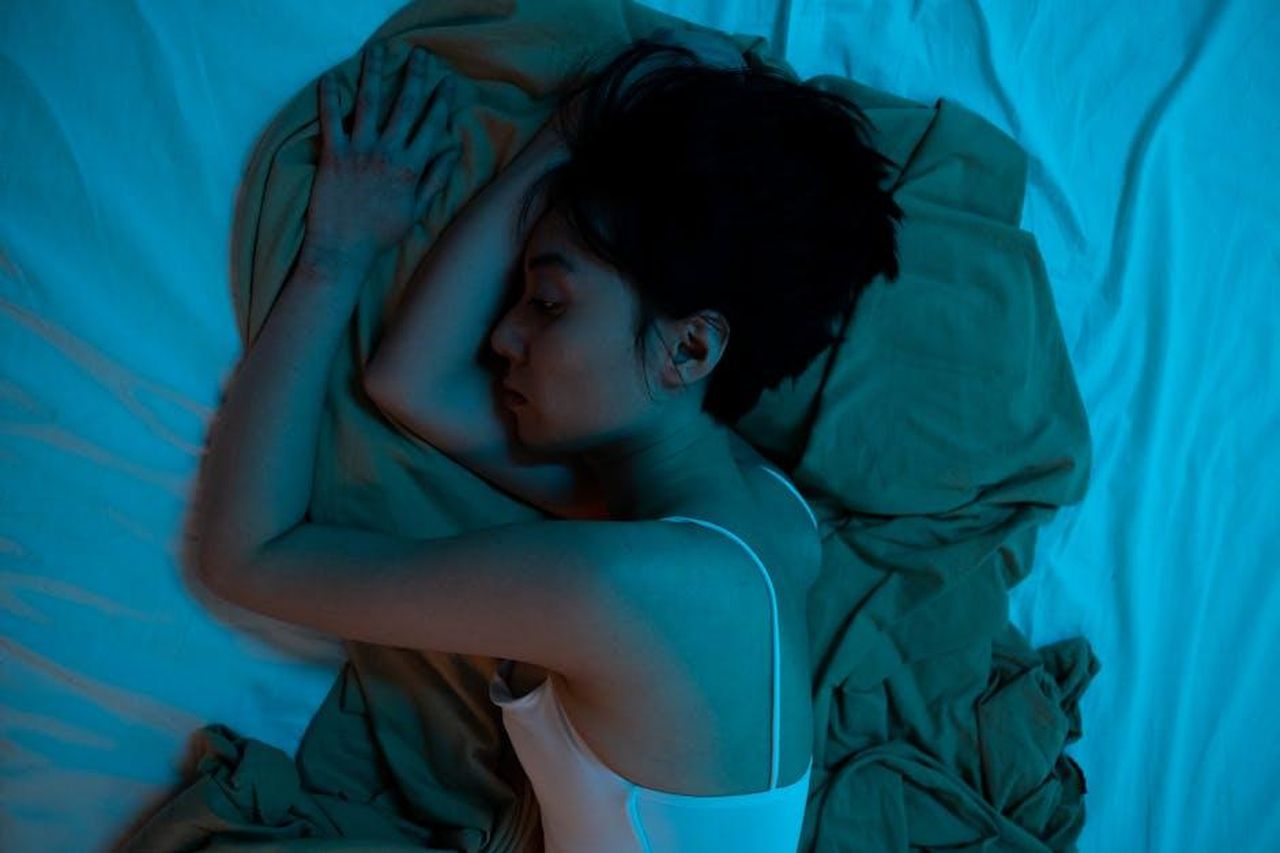 Le_lacrime_di_Deidre_kzVuwz97Nz - Confidenze24 Source: cottonbro studio - pexels - Asian woman lying on bed, expressing a contemplative mood, blue lighting.