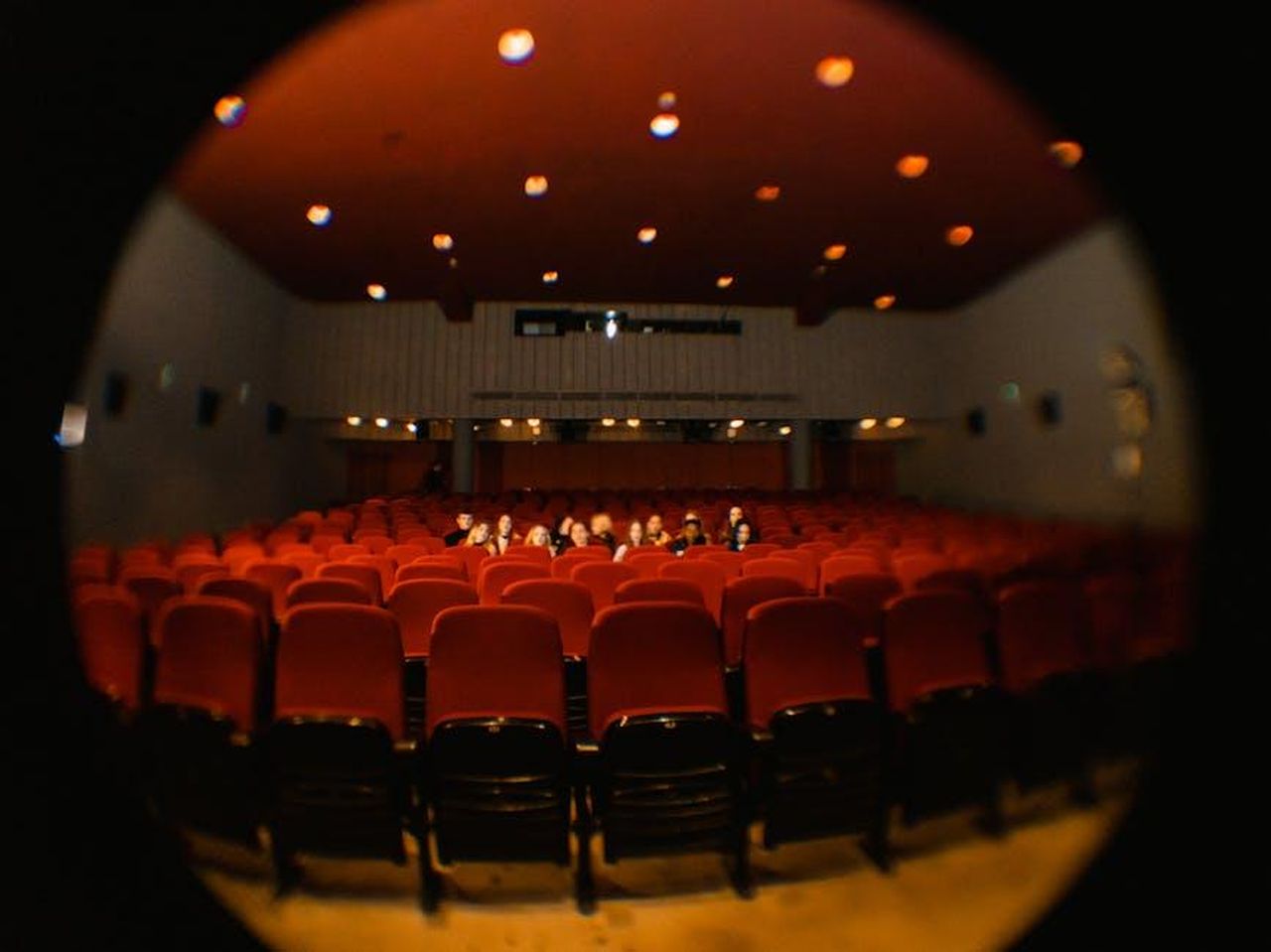 Le_lamentele_degli_spettatori_eRj0Kyrzij - Confidenze24 Source: Tima Miroshnichenko - pexels - A fisheye lens captures moviegoers in a dimly lit cinema, offering a unique perspective.