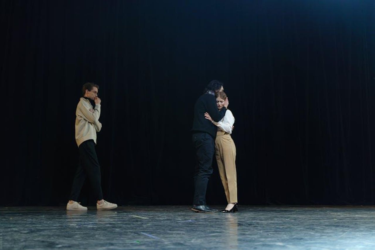 Le_motivazioni_dietro_le_assenze_TTDYzKb6nJ - Confidenze24 Source: cottonbro studio - pexels - Three actors performing a dramatic scene on stage, capturing emotional interaction.