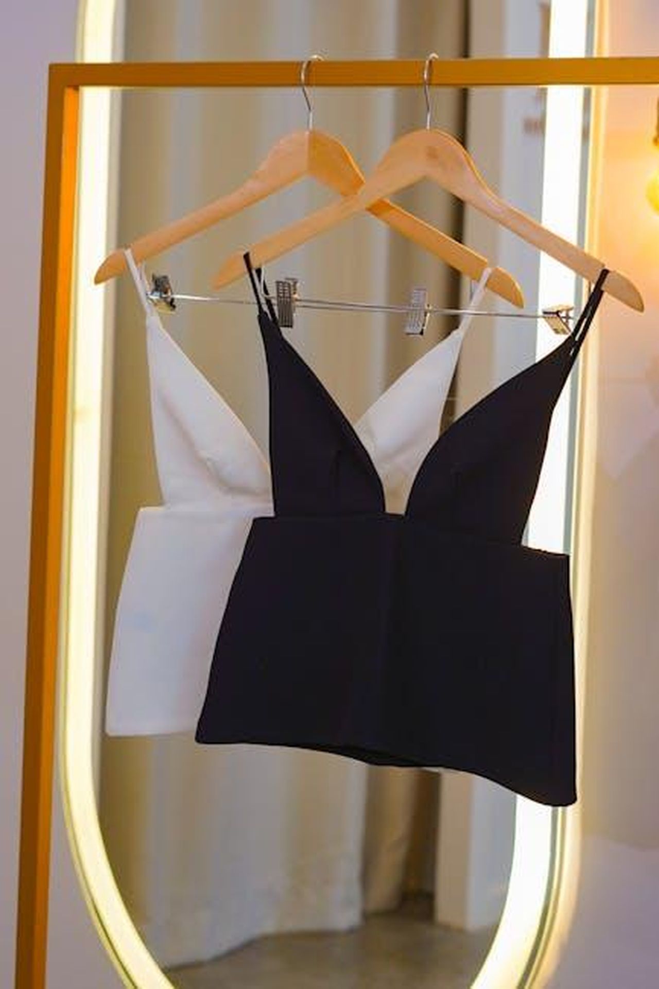 Le_parole_di_Serena_Williams_sulla_collezione_MtMXxu9mIs - Confidenze24 Source: pedro furtado - pexels - Stylish black and white tops on hangers in front of a golden mirror indoors.