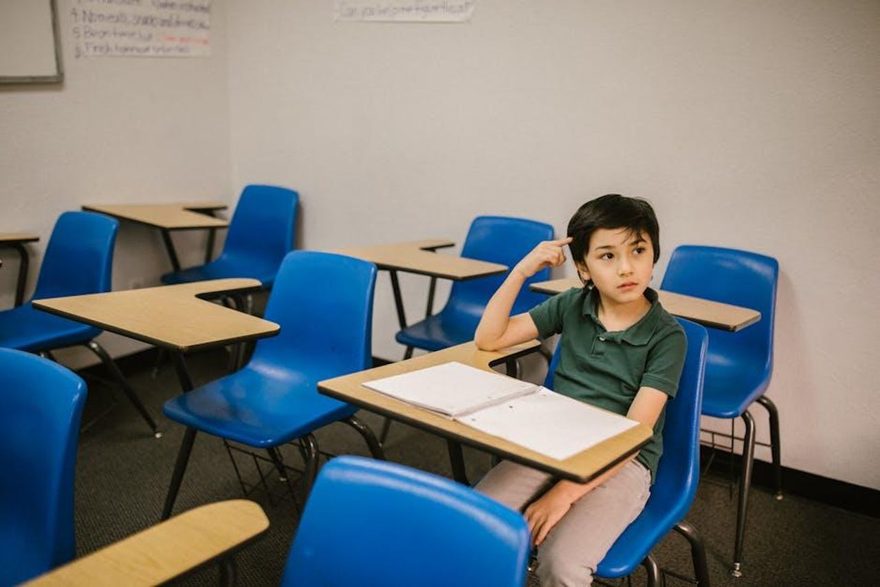 Le_parole_di_un_compagno_di_scuola_bfuviWnStl - Confidenze24 Source: RDNE Stock project - pexels - A young boy appears thoughtful while sitting alone in a classroom.