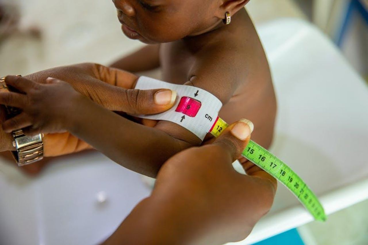 Le_preoccupazioni_per_il_benessere_dei_bambini_influencer_jZkQdXjoU7 - Confidenze24 Source: Lagos Food Bank Initiative - pexels - A healthcare professional measures a child's arm using MUAC tape for malnutrition assessment.