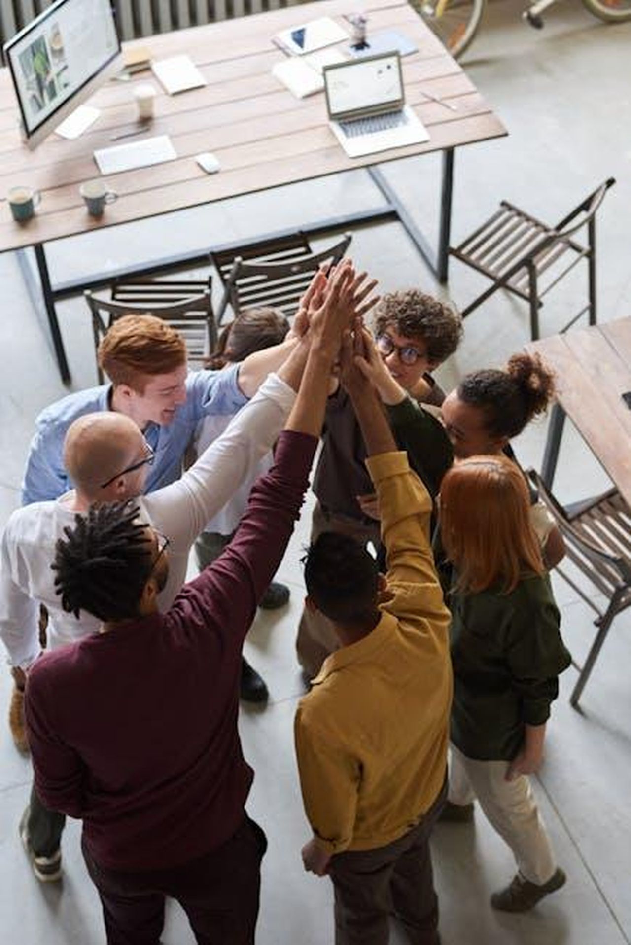 Le_ragioni_della_riconciliazione_NNGOPvl1U3 - Confidenze24 Source: fauxels - pexels - A diverse group of professionals high-fiving in a modern office, showcasing teamwork and collaboration.