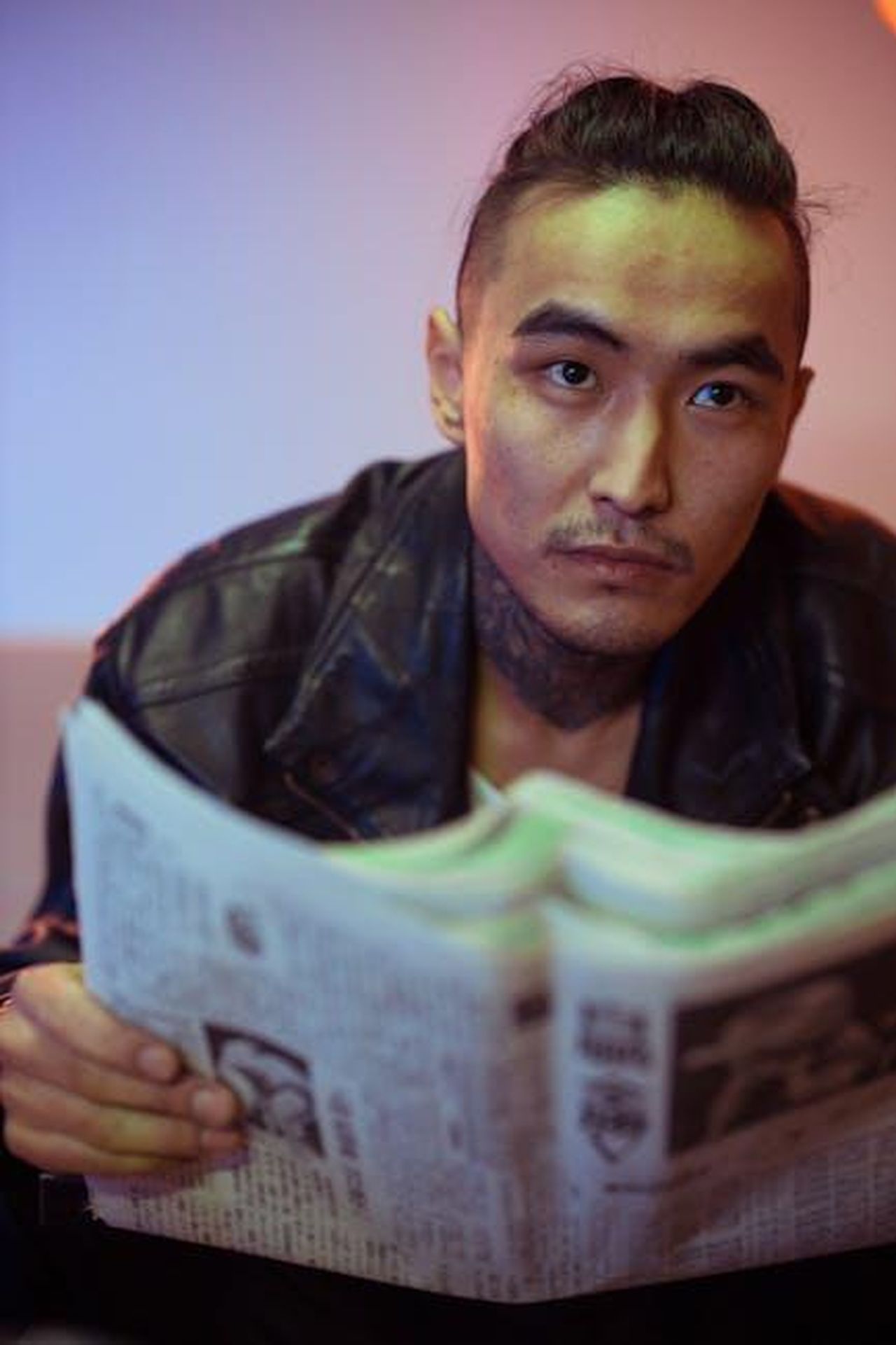 Le_reazioni_degli_utenti_sui_social_z1NFUzV7Oz - Confidenze24 Source: cottonbro studio - pexels - Man in leather jacket reading a newspaper, captured in a moody, modern portrait style.