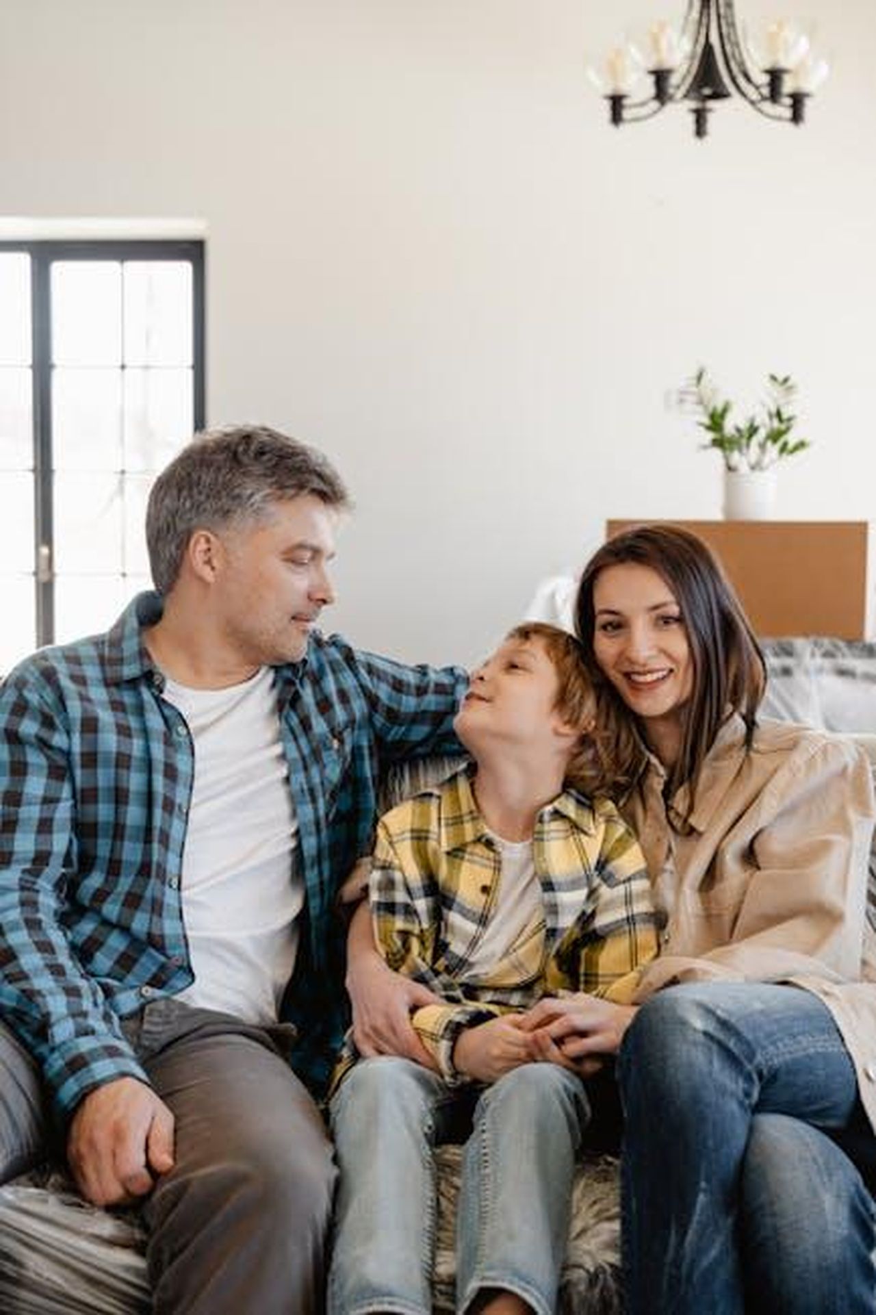 Le_reazioni_dei_figli_di_Lundgren_ceqmqeNSiN - Confidenze24 Source: MART PRODUCTION - pexels - A joyful family sitting together while unpacking in their new home living room.