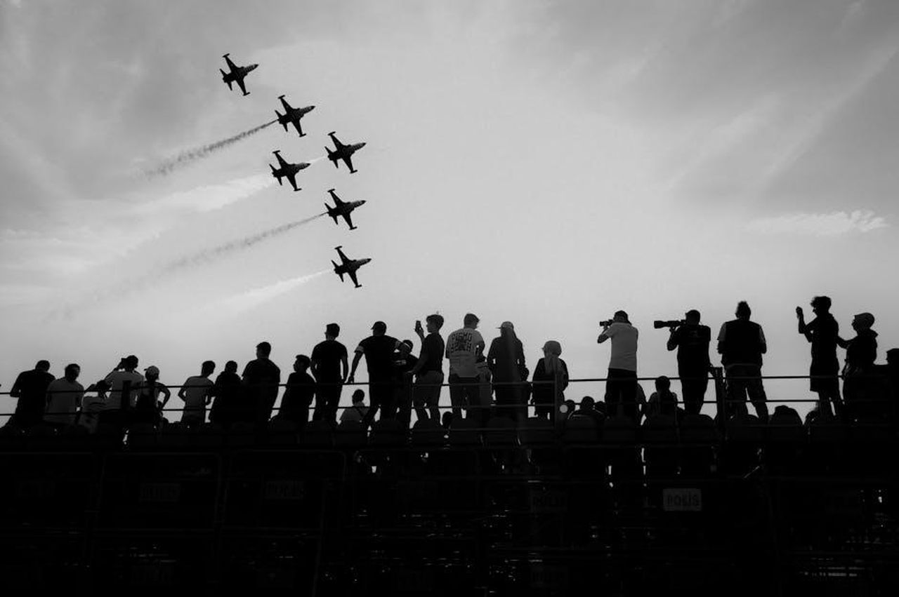 Le_reazioni_dei_telespettatori_di_Tipping_Point_tuhjj1Acew - Confidenze24 Source: Nesrin Öztürk - pexels - A dynamic aerobatic display with jets silhouetted against the sky, watched by a crowd.