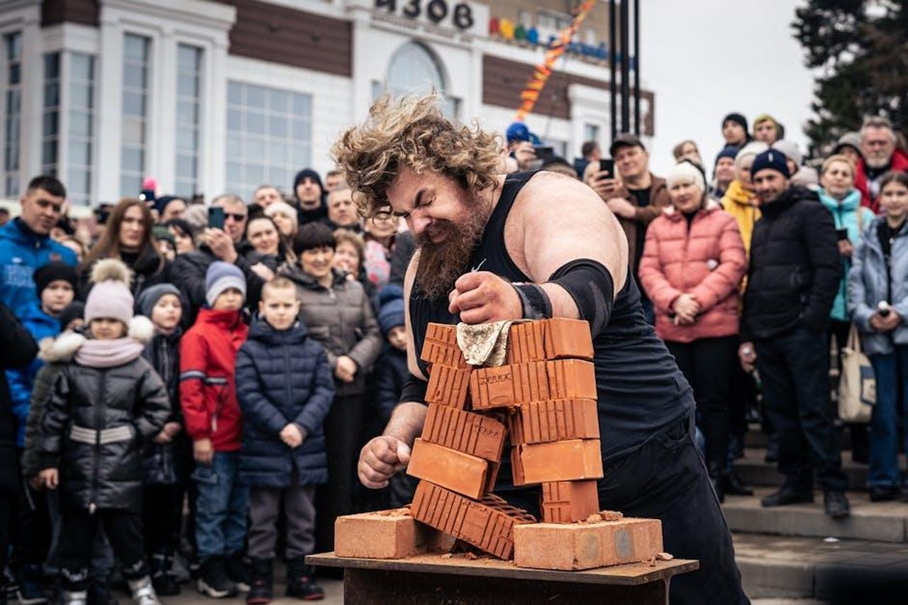 Le_reazioni_dei_telespettatori_eZsGP2Jl2e - Confidenze24 Source: Alexa Popovich - pexels - A strongman performs a brick-breaking demonstration before an intrigued crowd outdoors.
