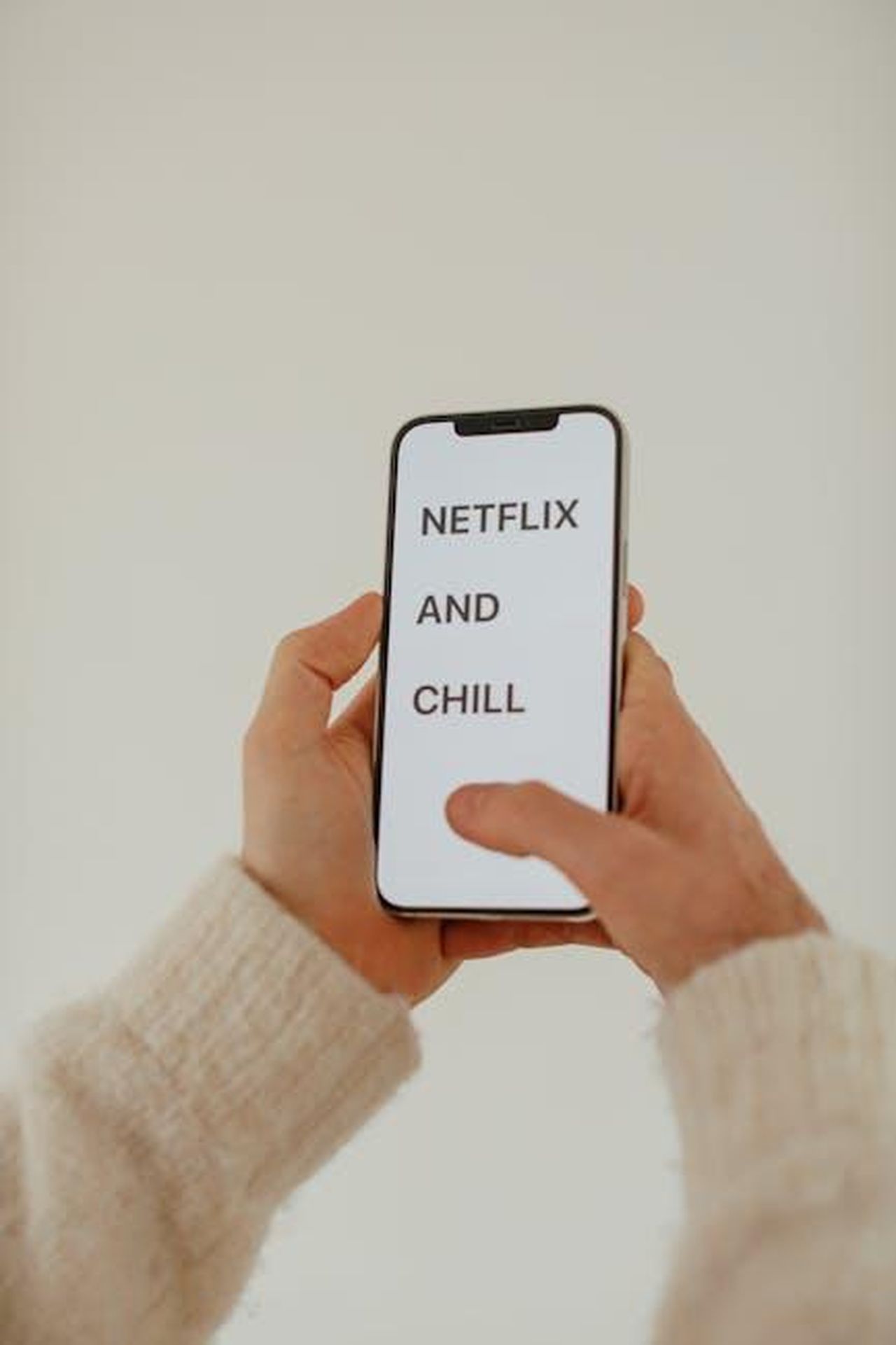 Le_reazioni_negative_e_la_difesa_di_Paris_Hilton_kiFOBakeNv - Confidenze24 Source: Cup of Couple - pexels - Person holding a smartphone displaying 'Netflix and Chill' text, cozy setting.