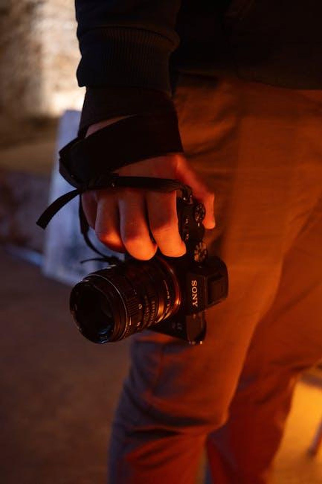 Le_reazioni_online_e_il_dibattito_sulluso_degli_intimacy_coordinators_t7U8TOxORQ - Confidenze24 Source: Eyüpcan Timur - pexels - A person holding a Sony camera indoors with warm lighting.